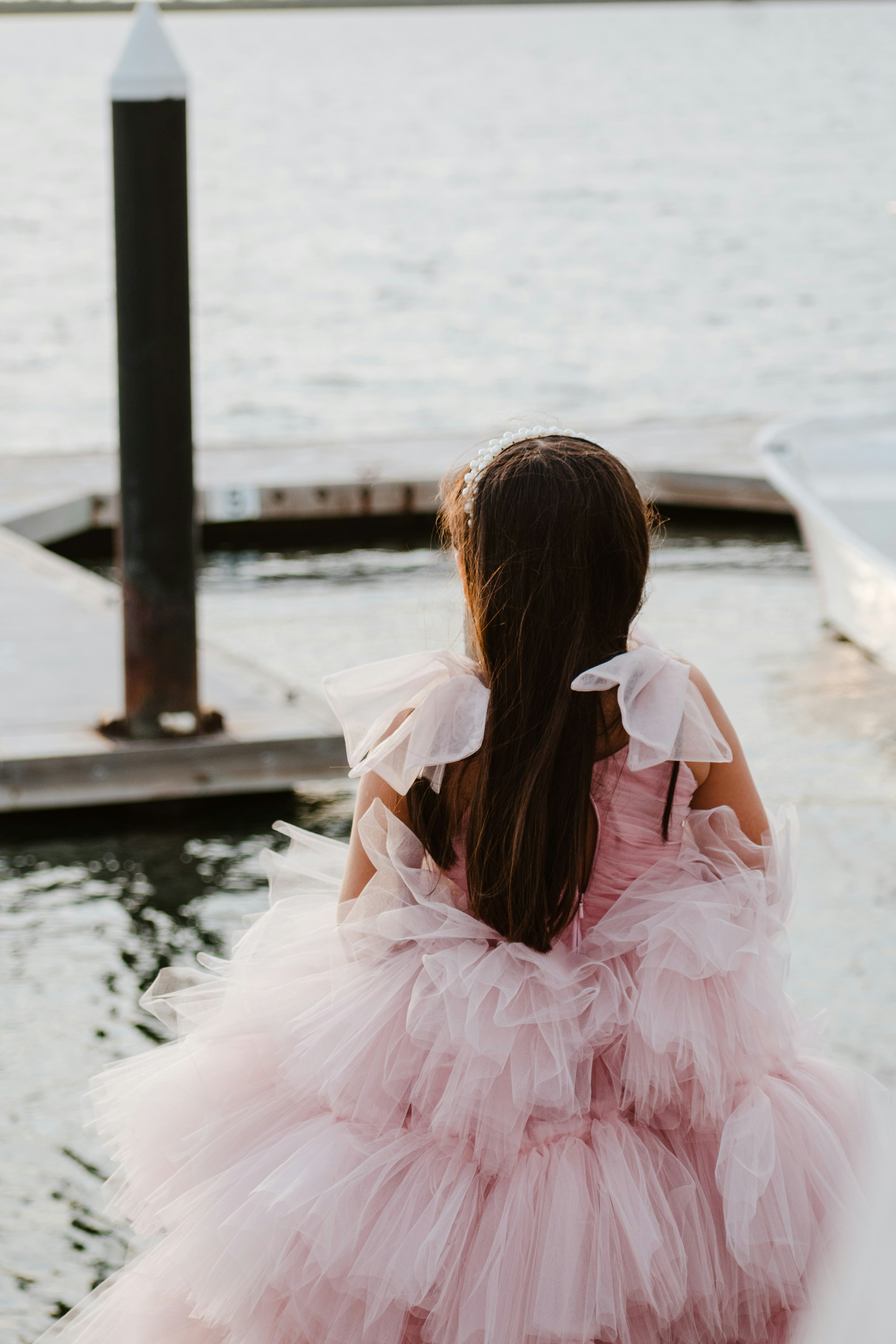 Girl in a pink dress by the water