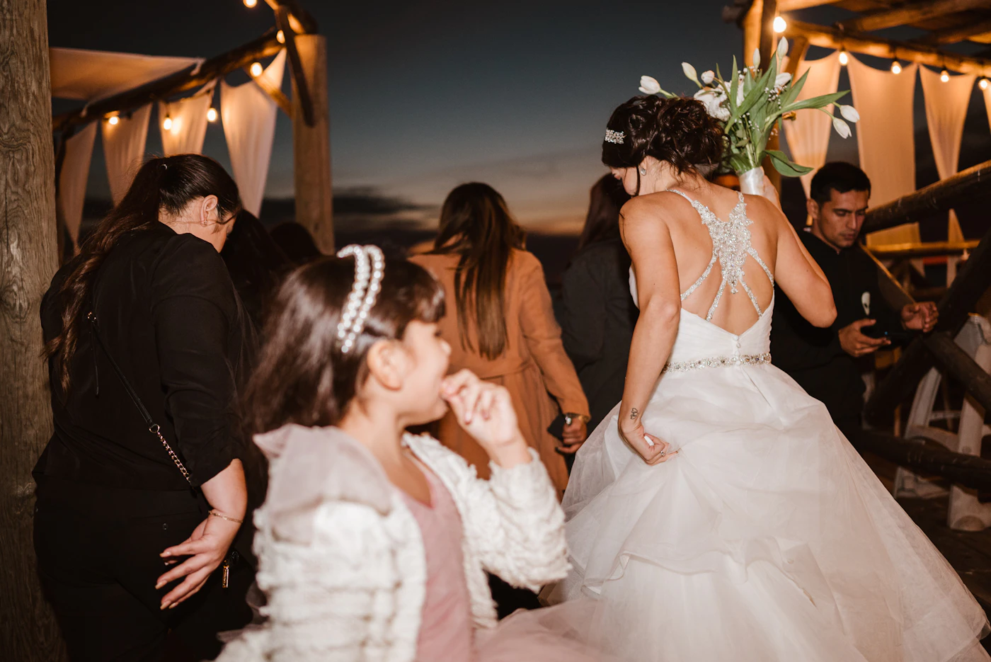 Wedding guests celebrating with a bride at an outdoor reception
