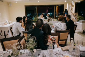 Wedding guests seated at decorated tables at night.