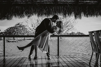 Couple kissing on a wooden deck by the water