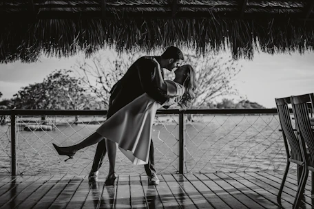 Couple kissing on a wooden deck by the water
