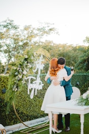 Couple embracing at an outdoor wedding ceremony.