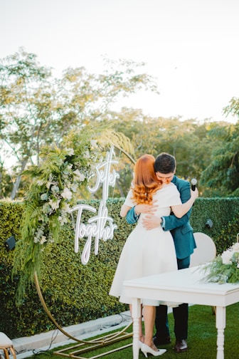 Couple embracing at an outdoor wedding ceremony.