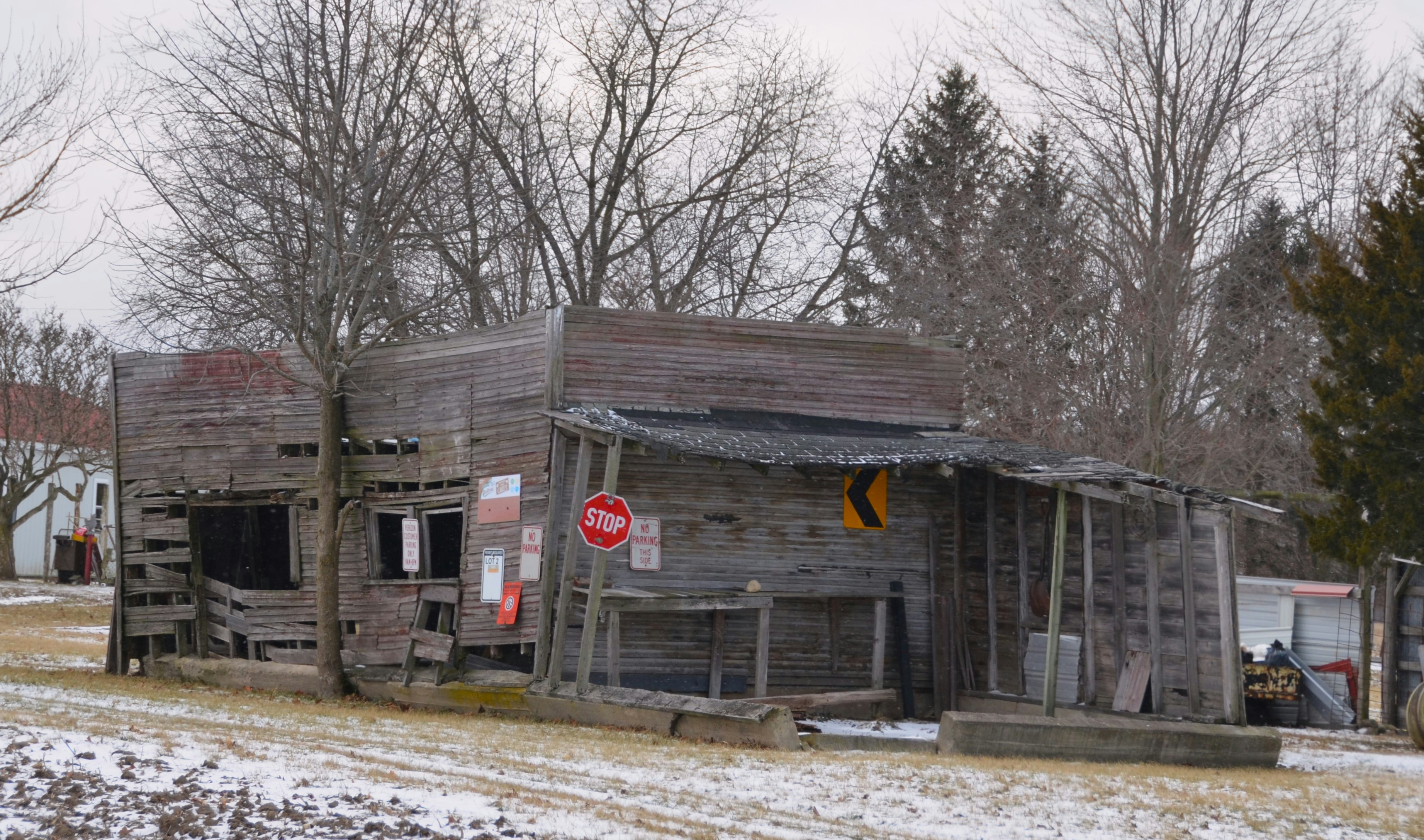 Dilapidated wooden building with a stop sign.