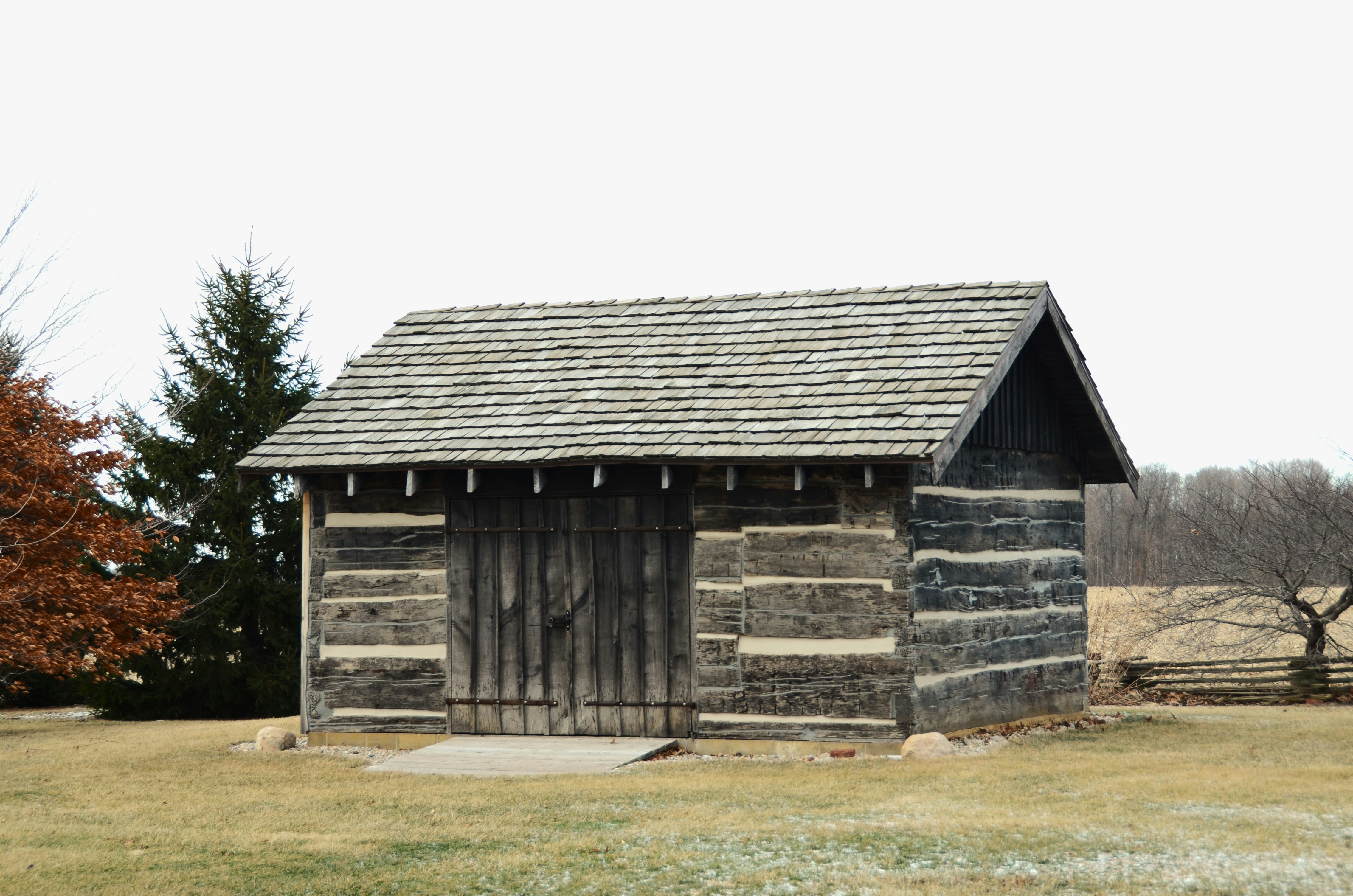 A rustic log cabin with a wooden door.