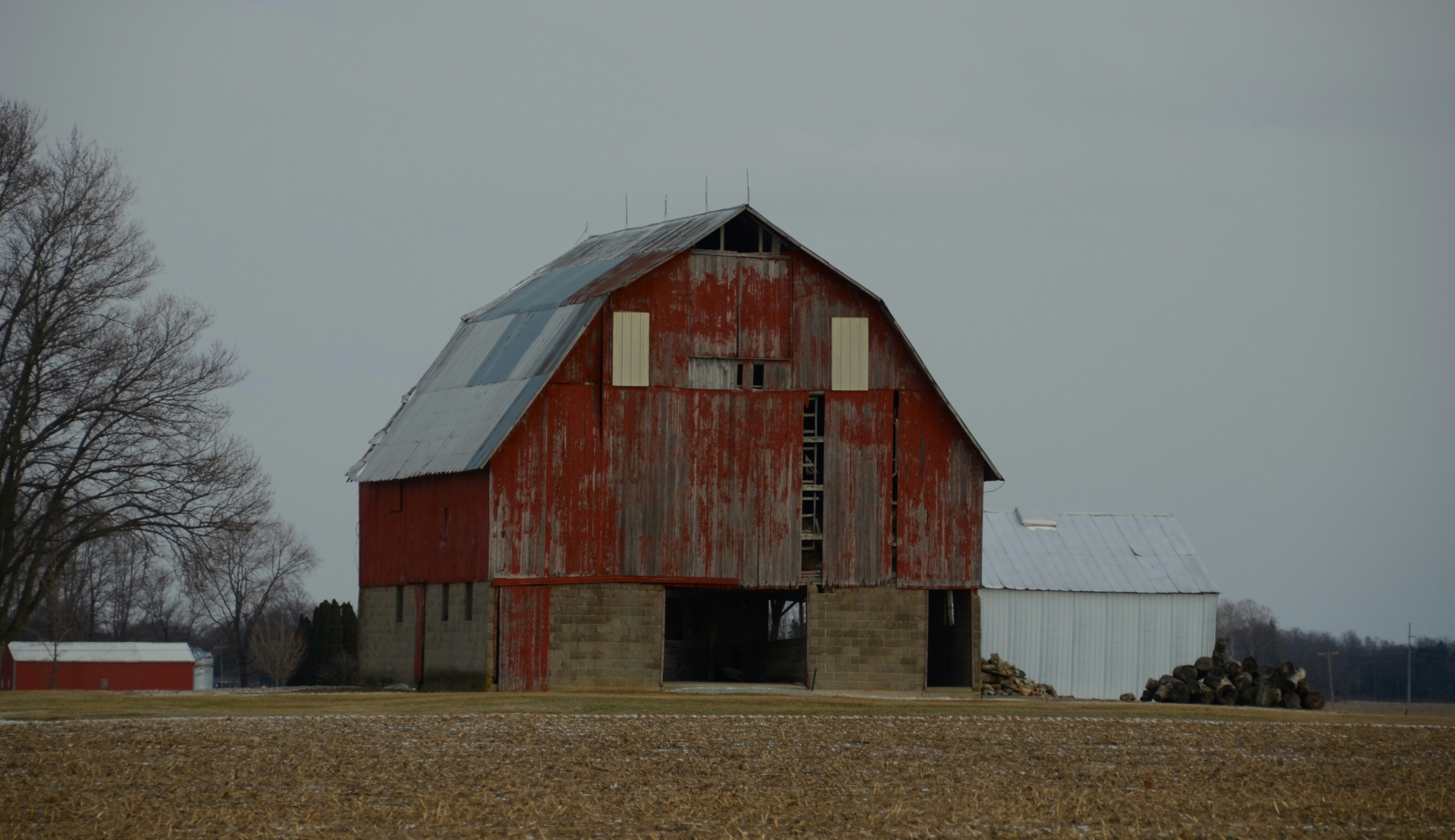 An old red barn stands in a field.