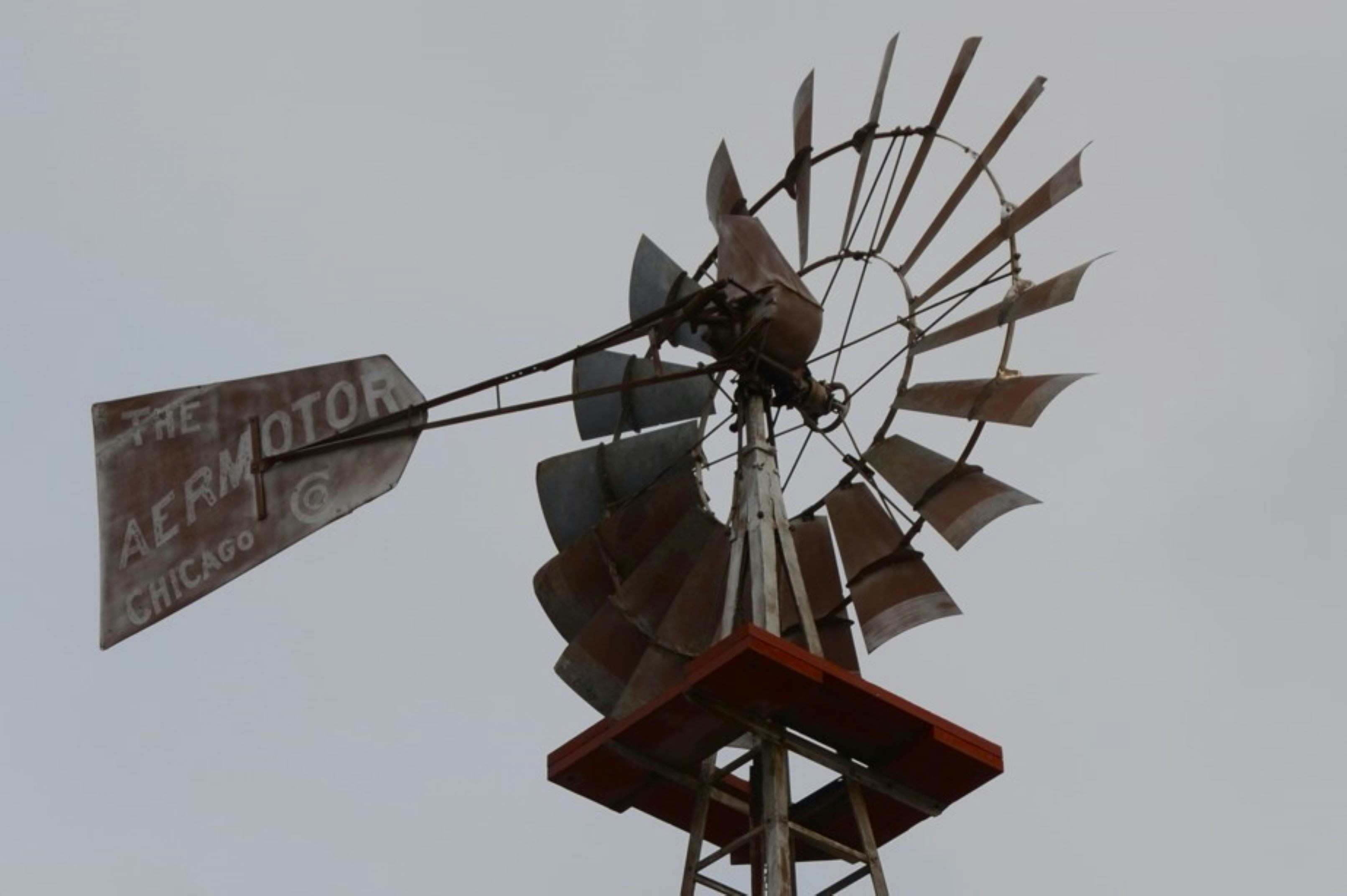 An old aermotor windmill against a cloudy sky