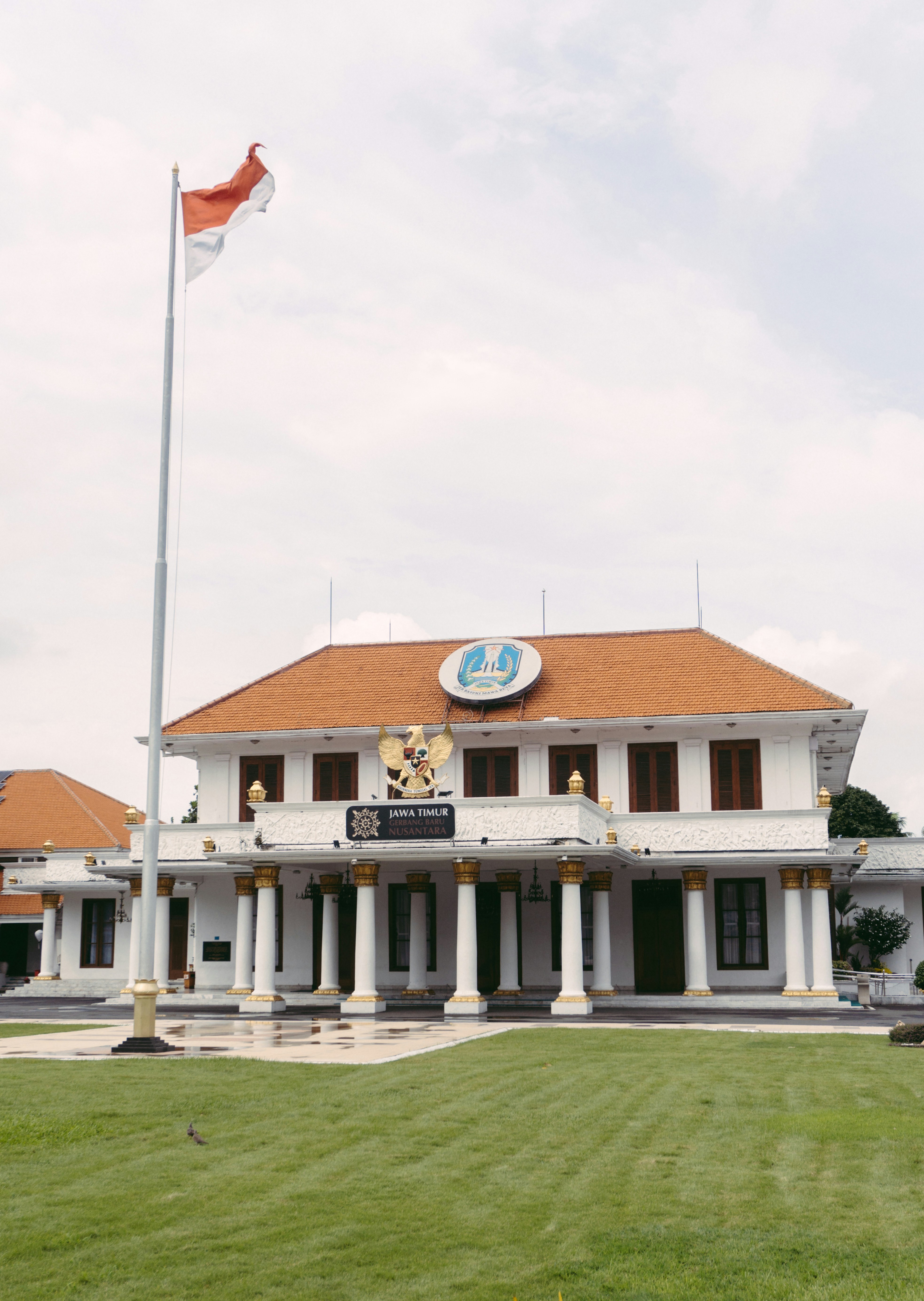 Weißes Gebäude mit Säulen und indonesischer Flagge