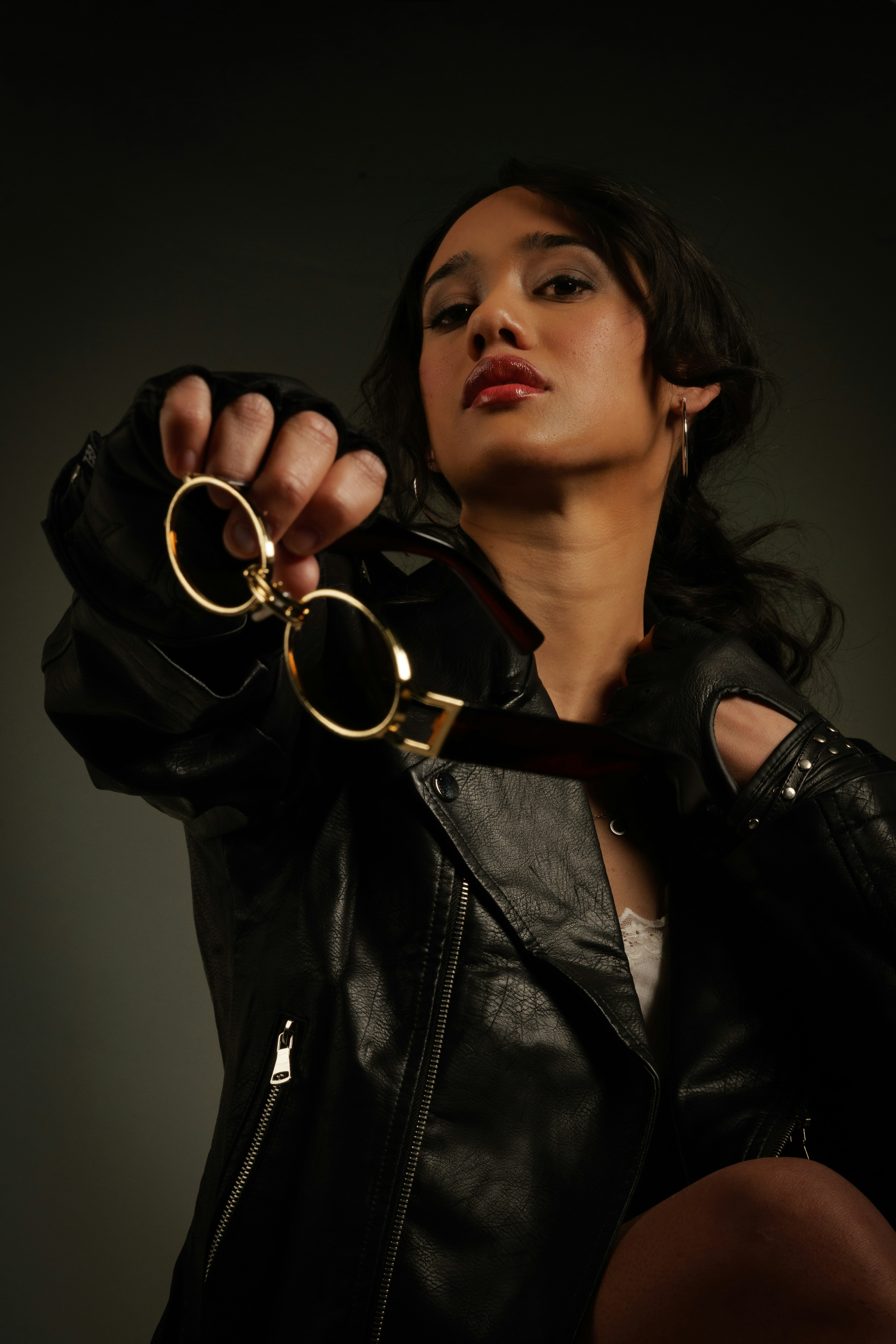Woman in leather jacket holding handcuffs