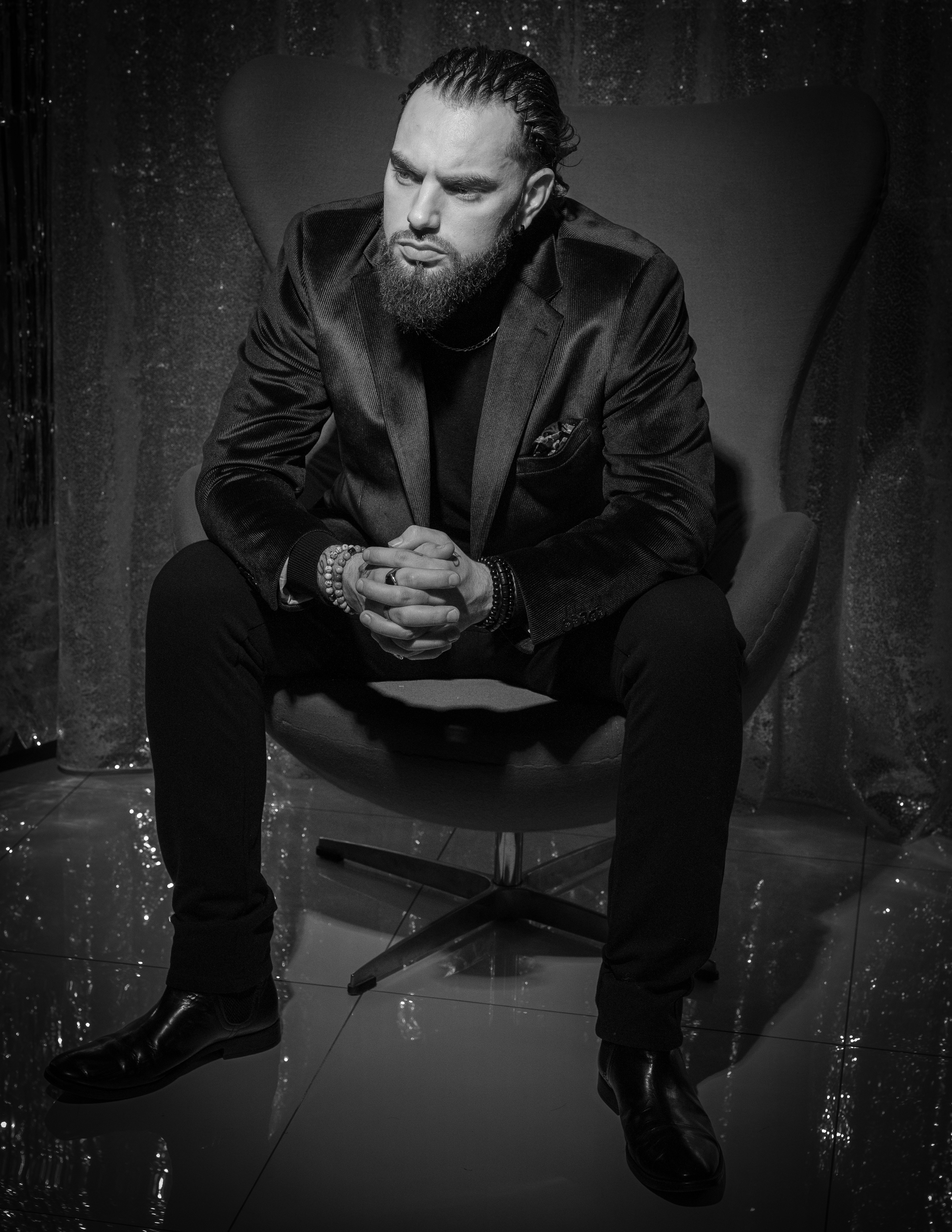 Man in velvet blazer sitting in chair