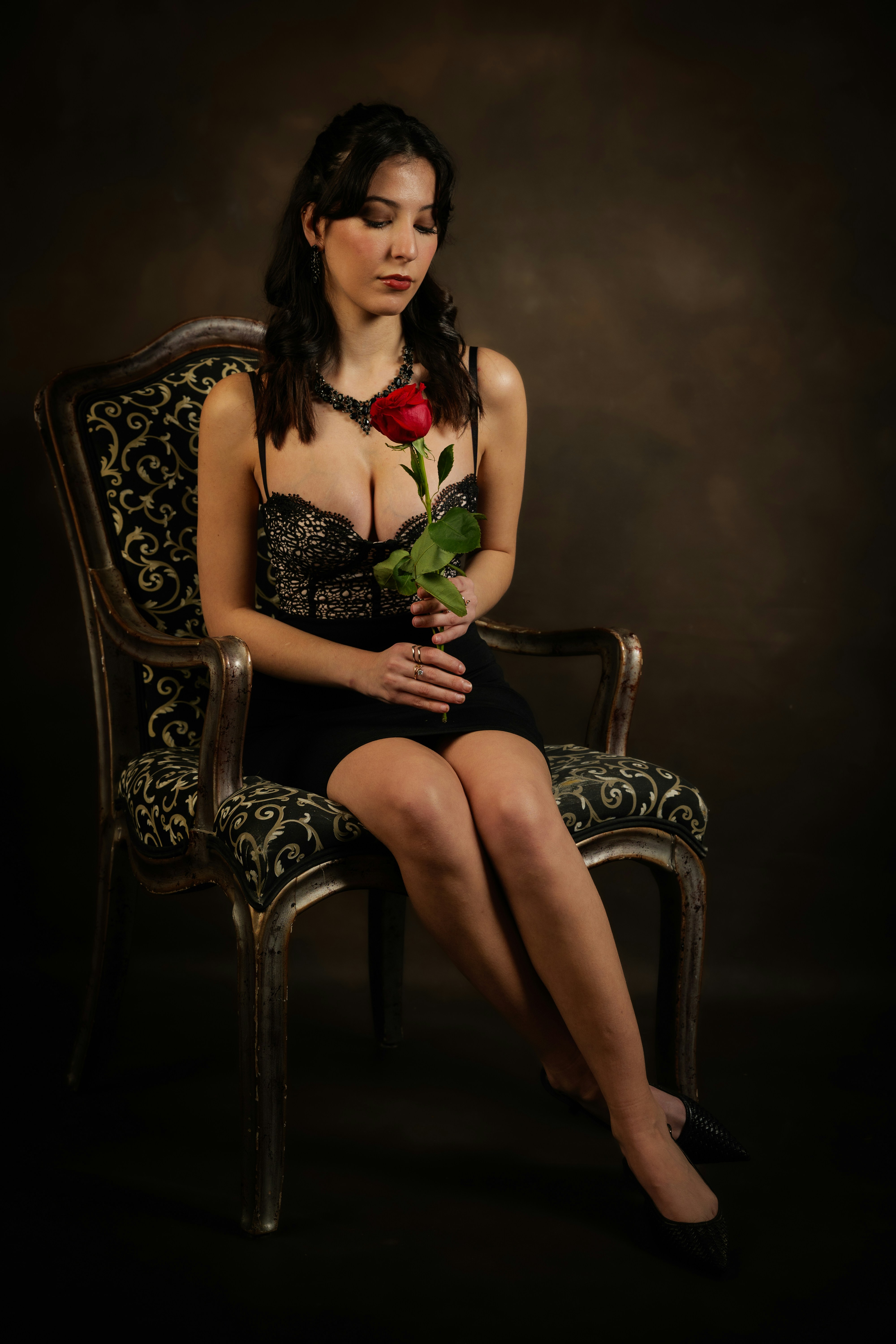 Woman in elegant dress holding a red rose