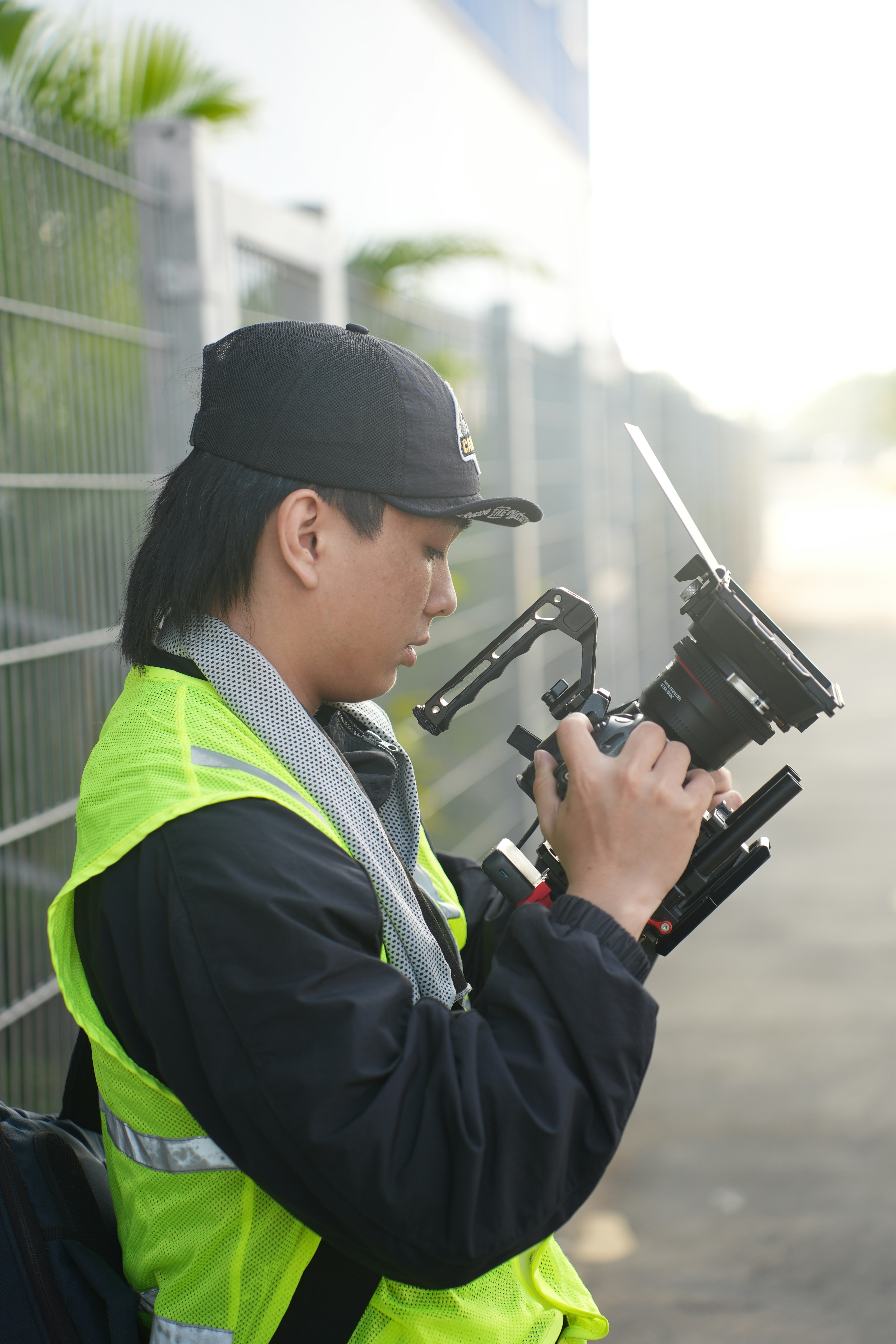 A person operating a professional camera rig outdoors.