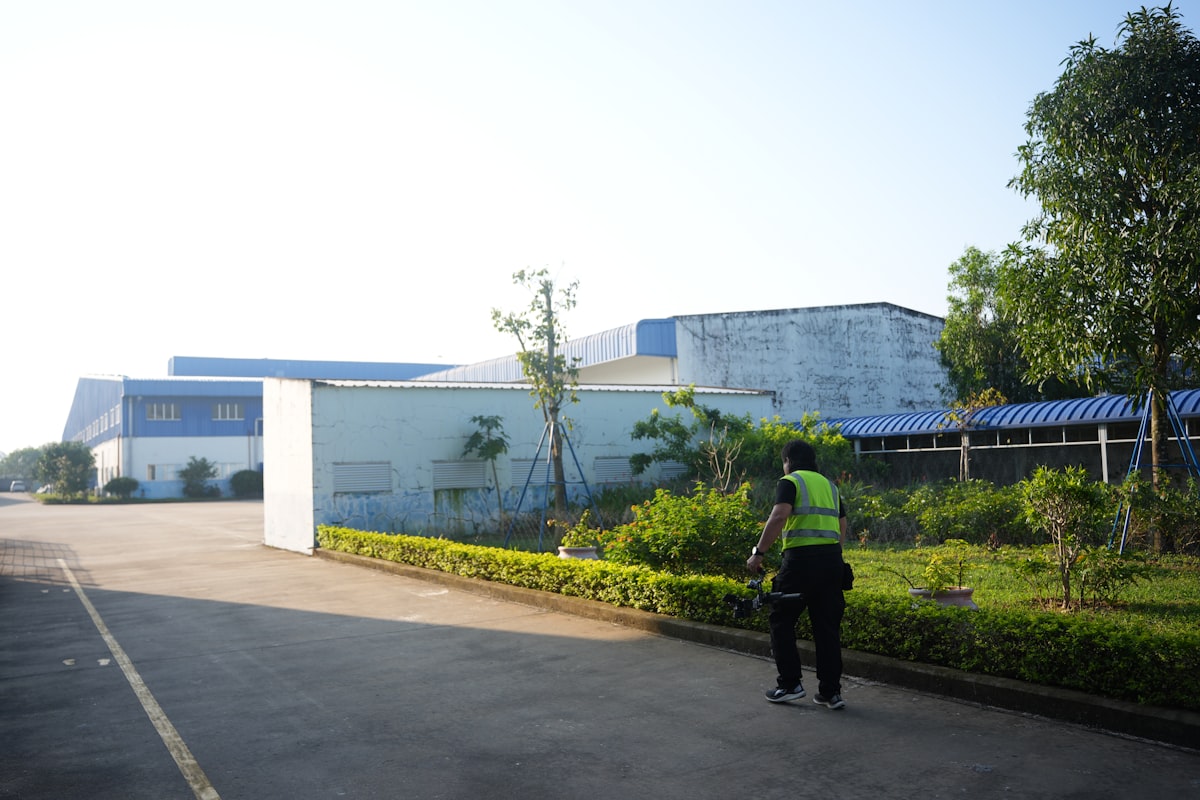 Professional in a high-visibility vest next to an industrial building during an inspection