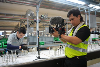 Filmmaker records workers in a factory production line.