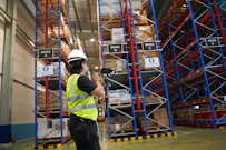 Worker scanning inventory in a large warehouse