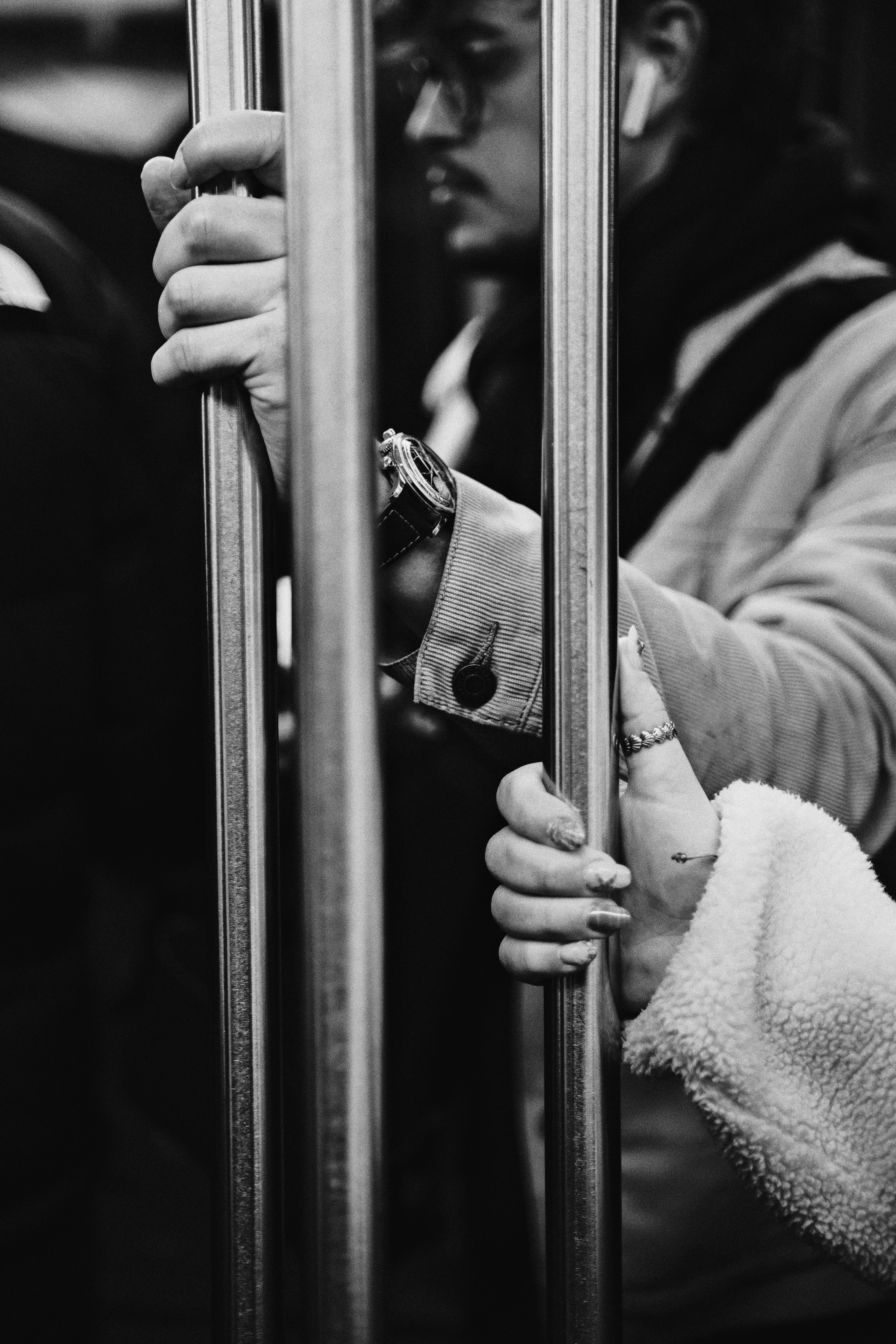 People holding onto bars inside a moving vehicle.