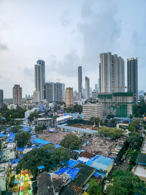 Modern skyscrapers tower over a dense urban slum.