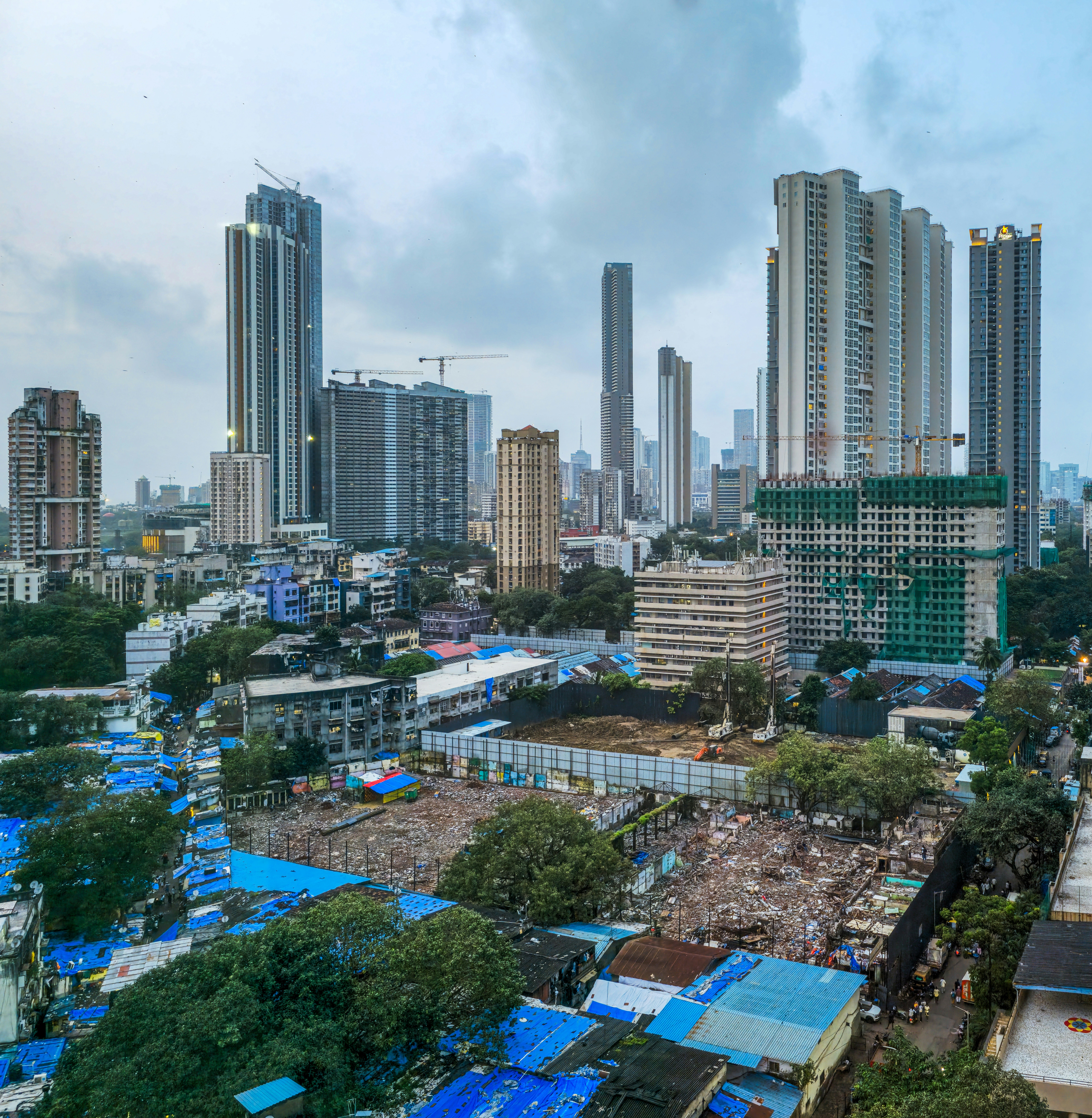 Modern skyscrapers rise above a densely populated urban area.