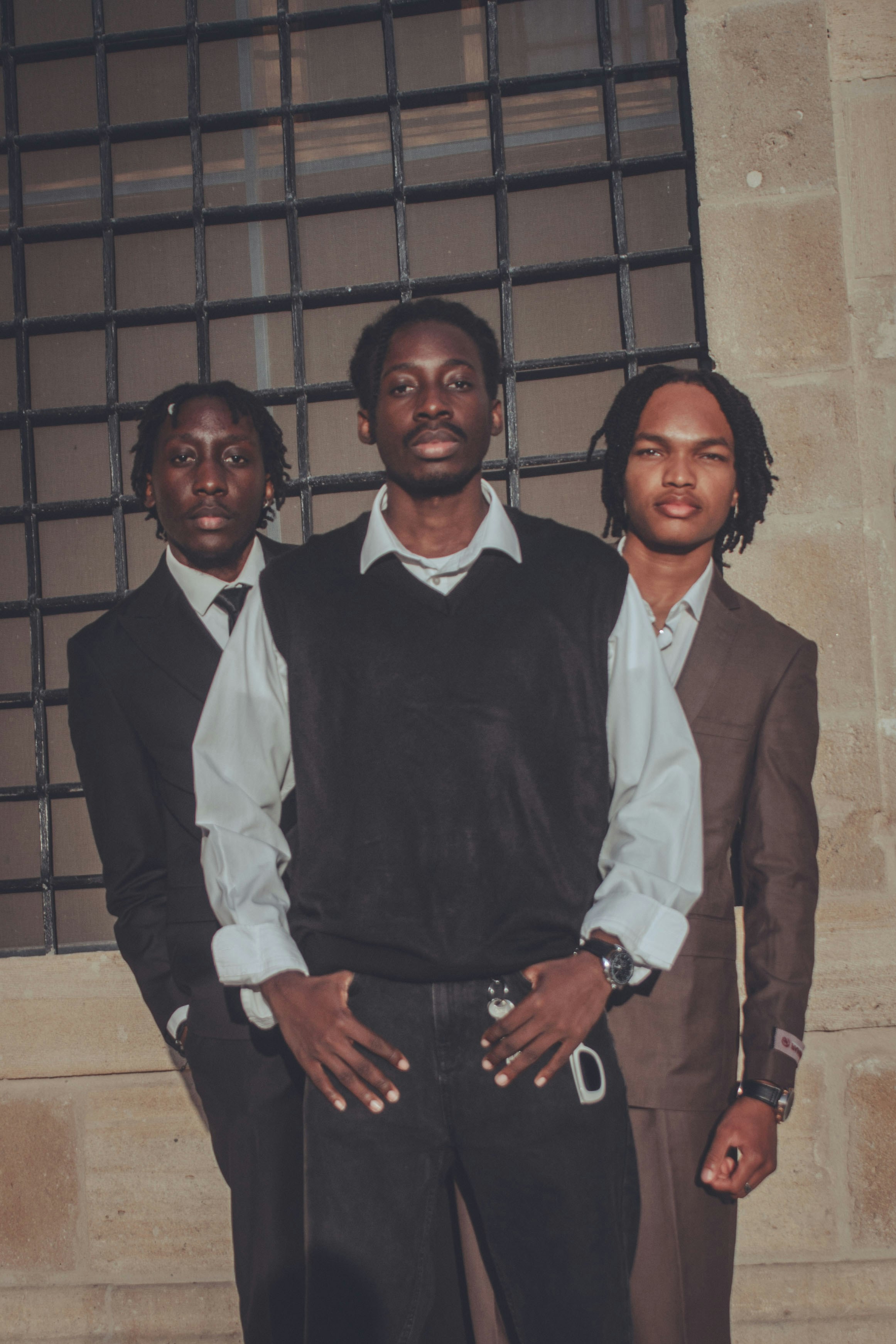 Three young men in formal attire standing together.