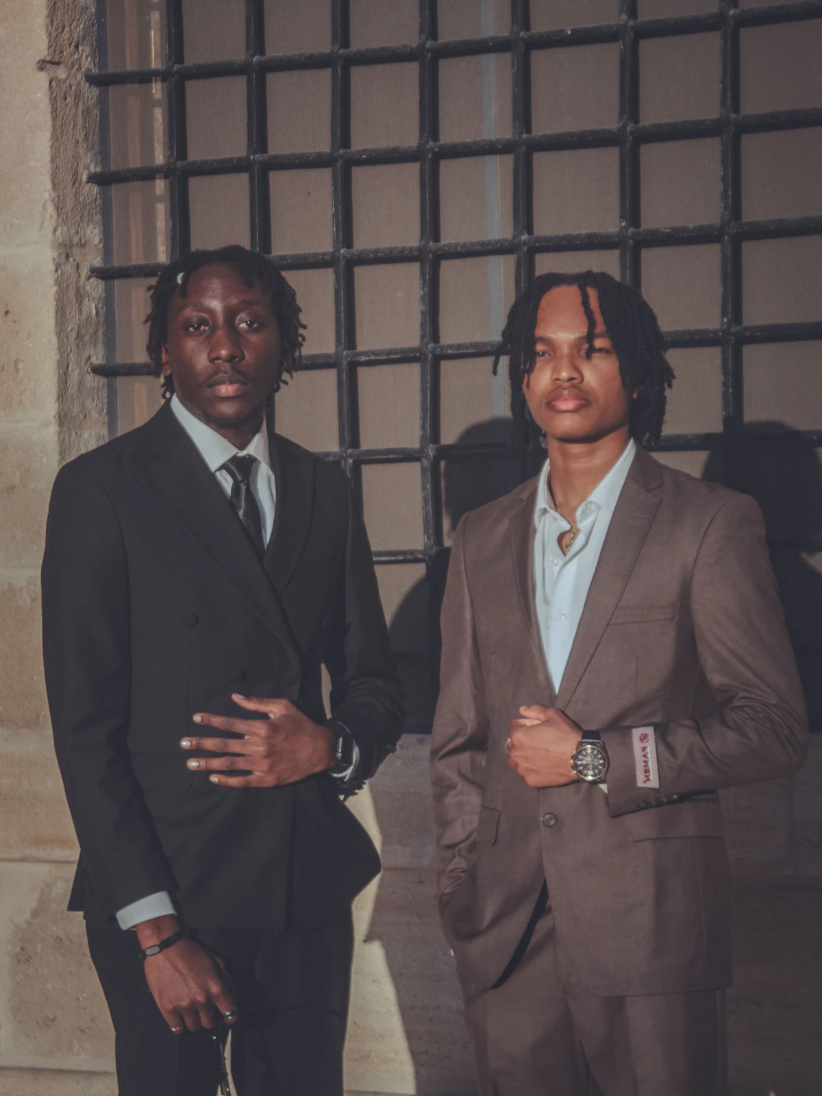 Two young men in suits standing outside