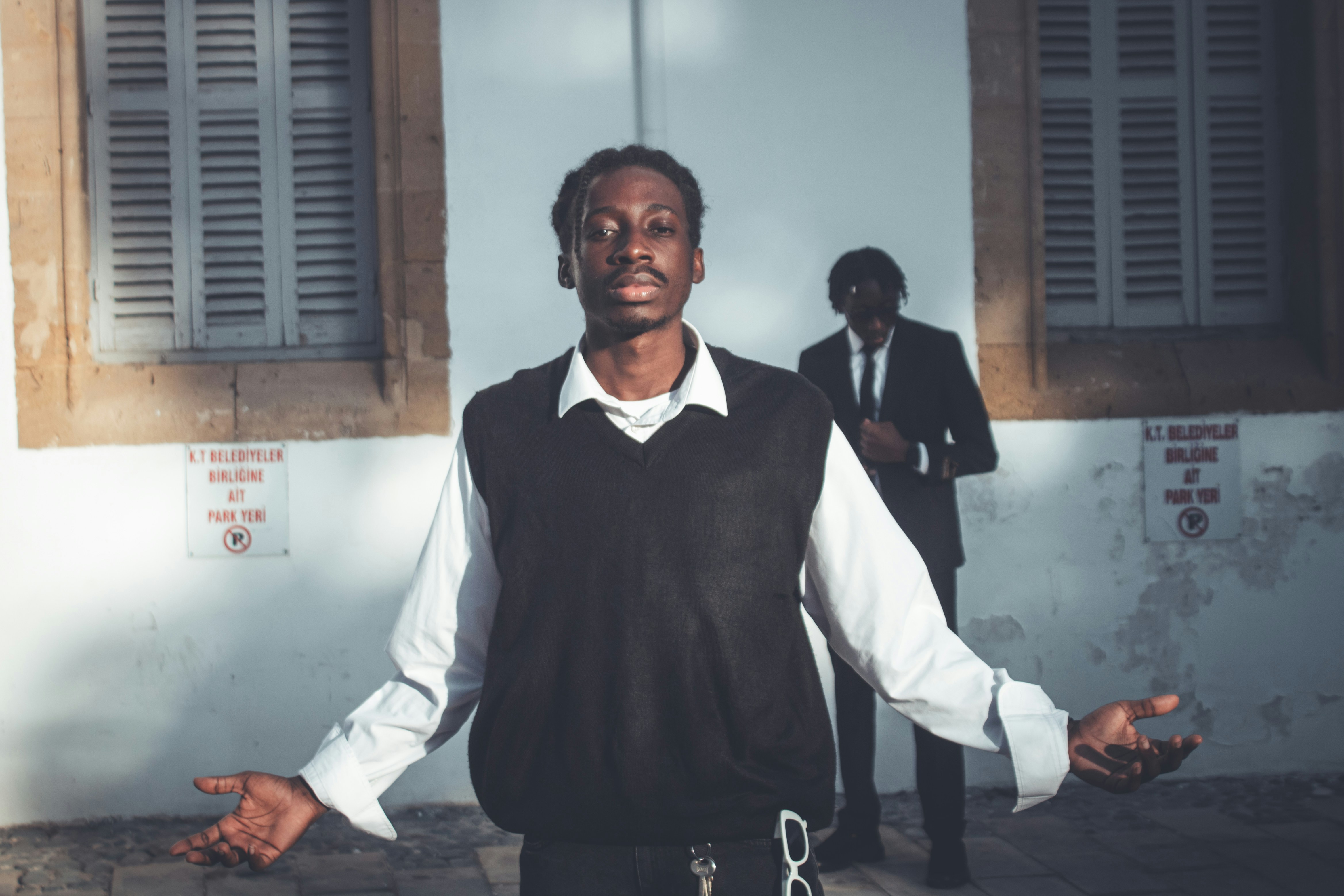 Two men in formal wear stand outside building.