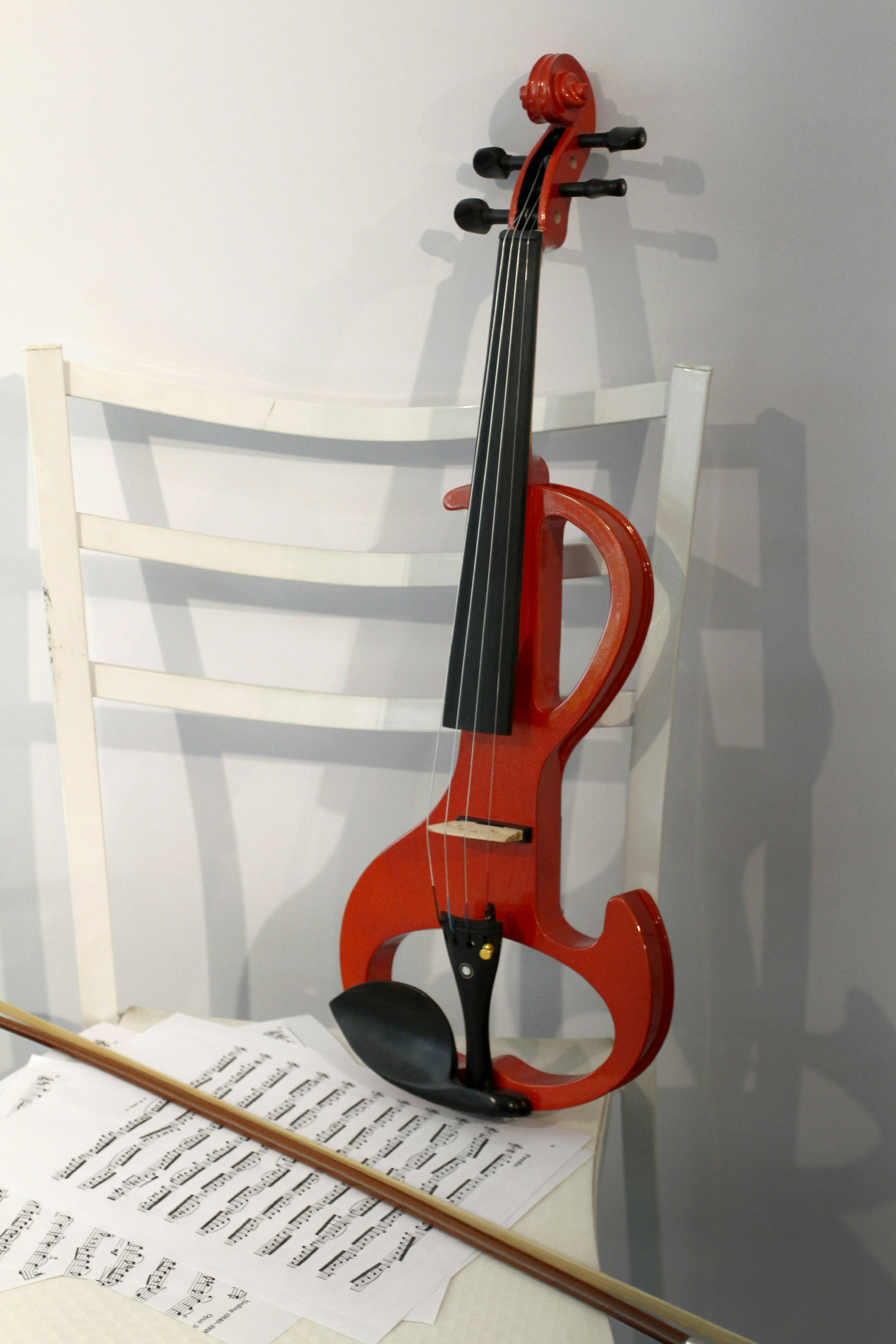 A bright orange electric violin rests on a chair.