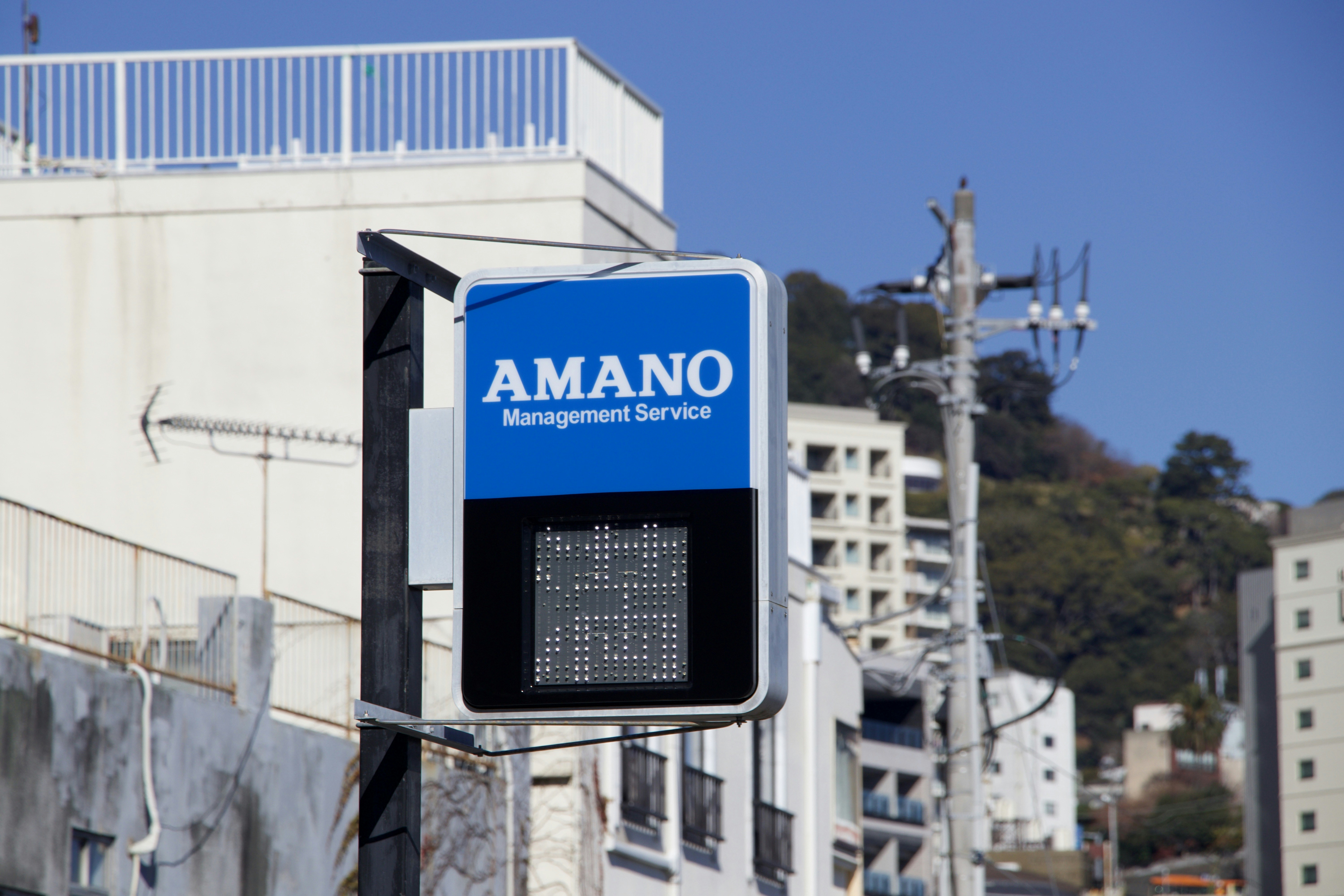 A blue sign with amano management service logo.