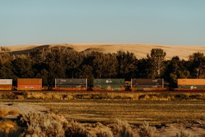 A freight train travels through a dry, rural landscape.