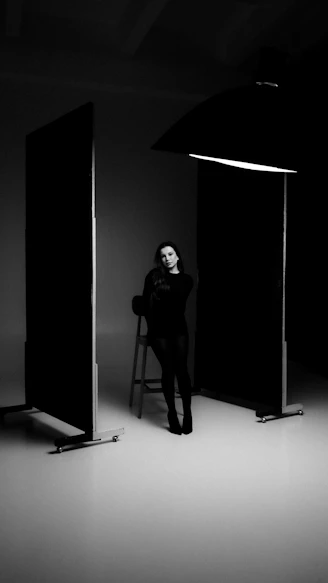 Woman sitting on a stool in a studio.