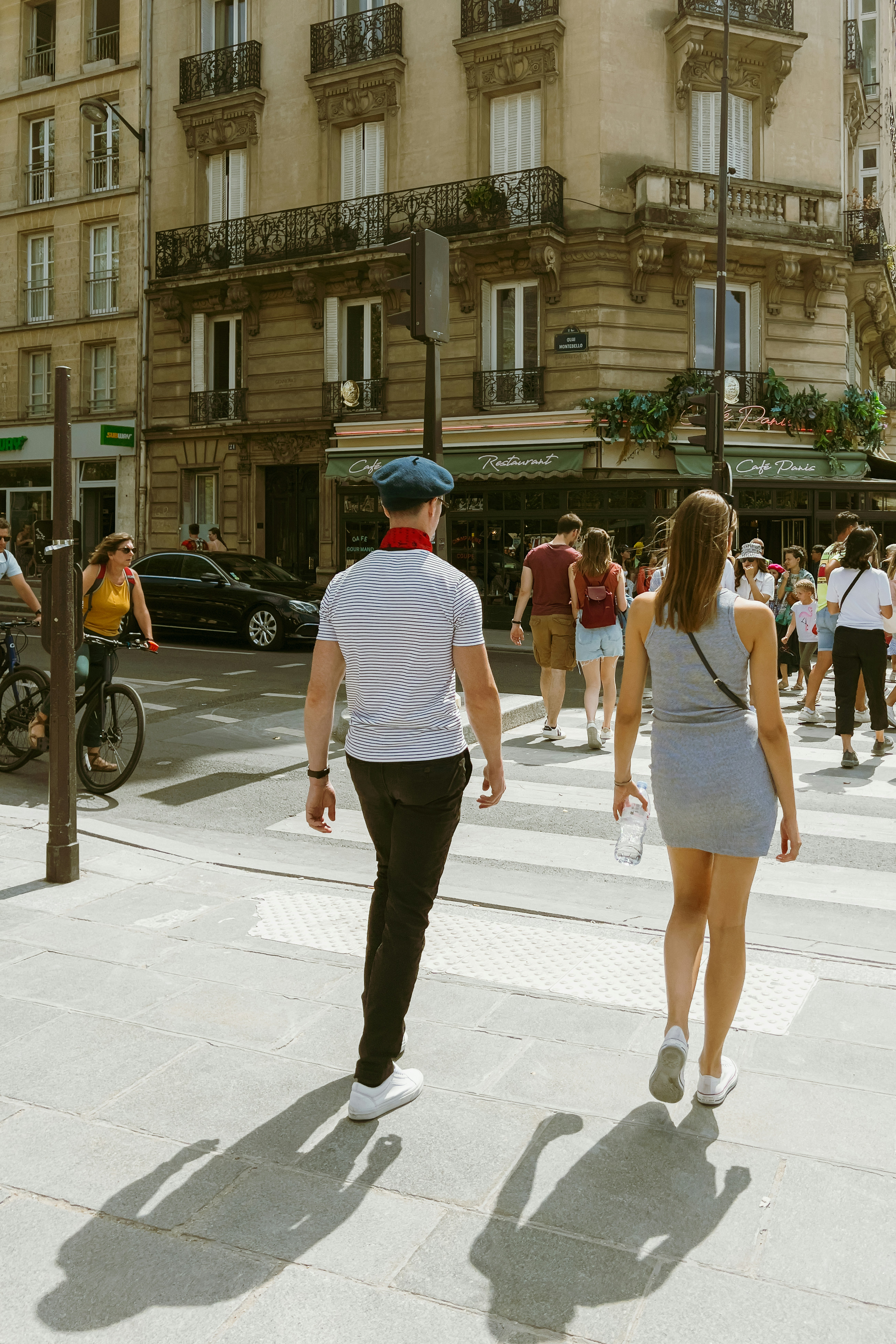 Couple crossing a street in paris with shadows.