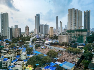 Modern skyscrapers overlook a dense urban slum.