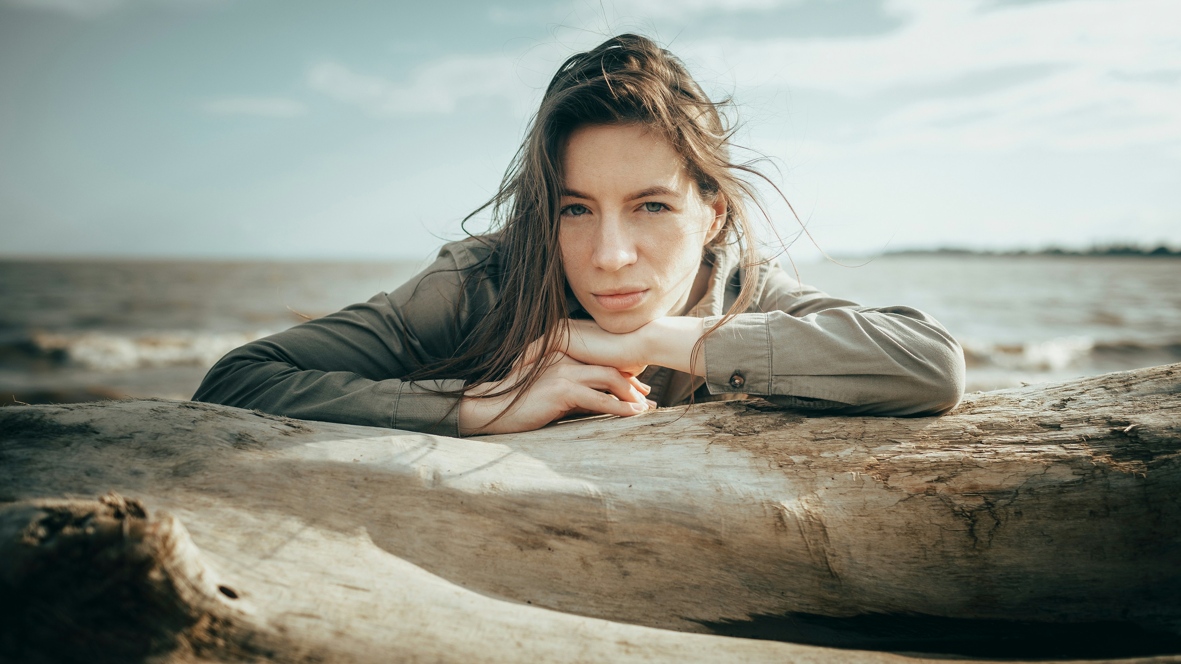 Woman resting her chin on her hands by the water