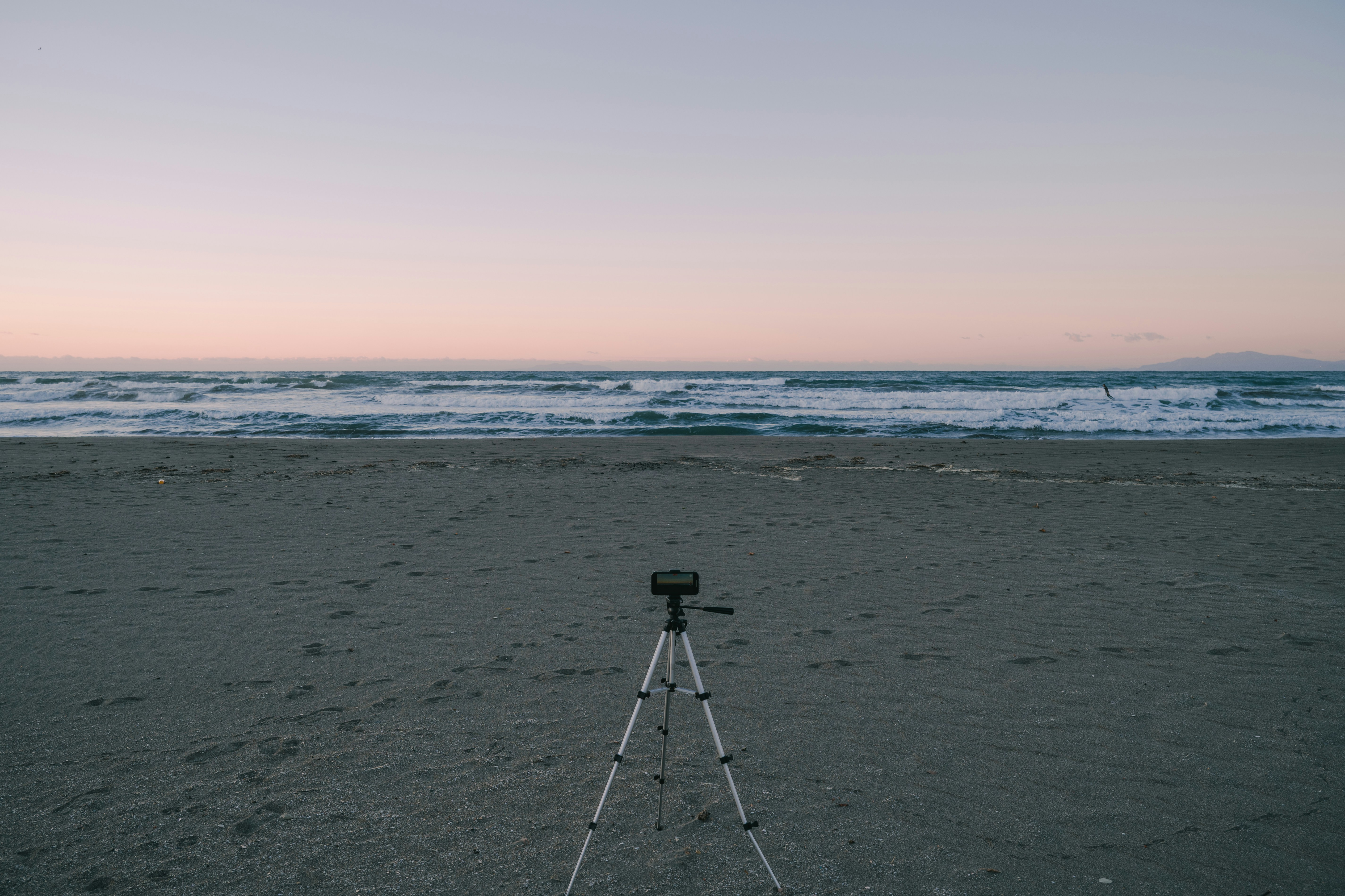 Tripod on a beach facing the ocean waves