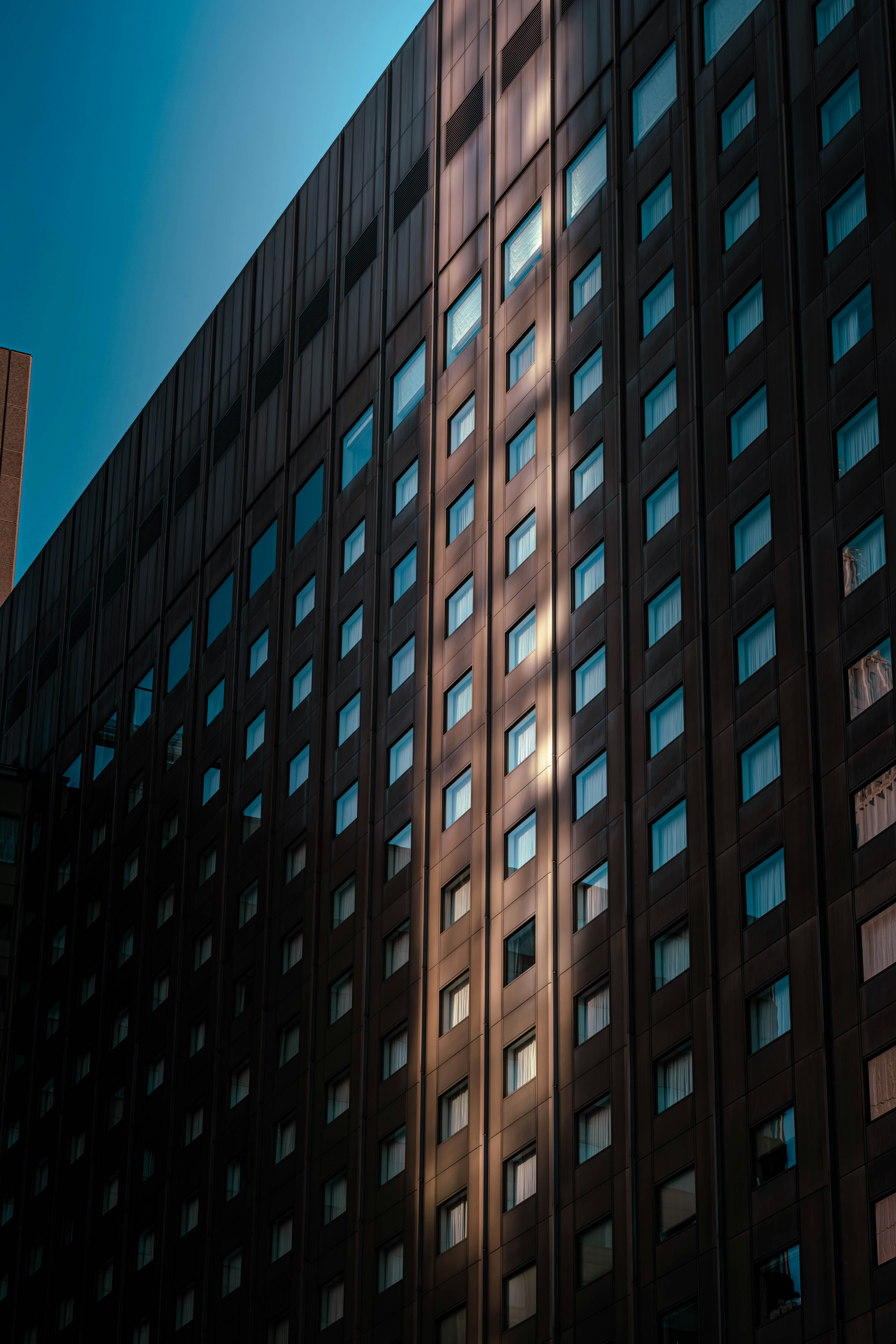 Modern building facade with sunlight reflecting on windows