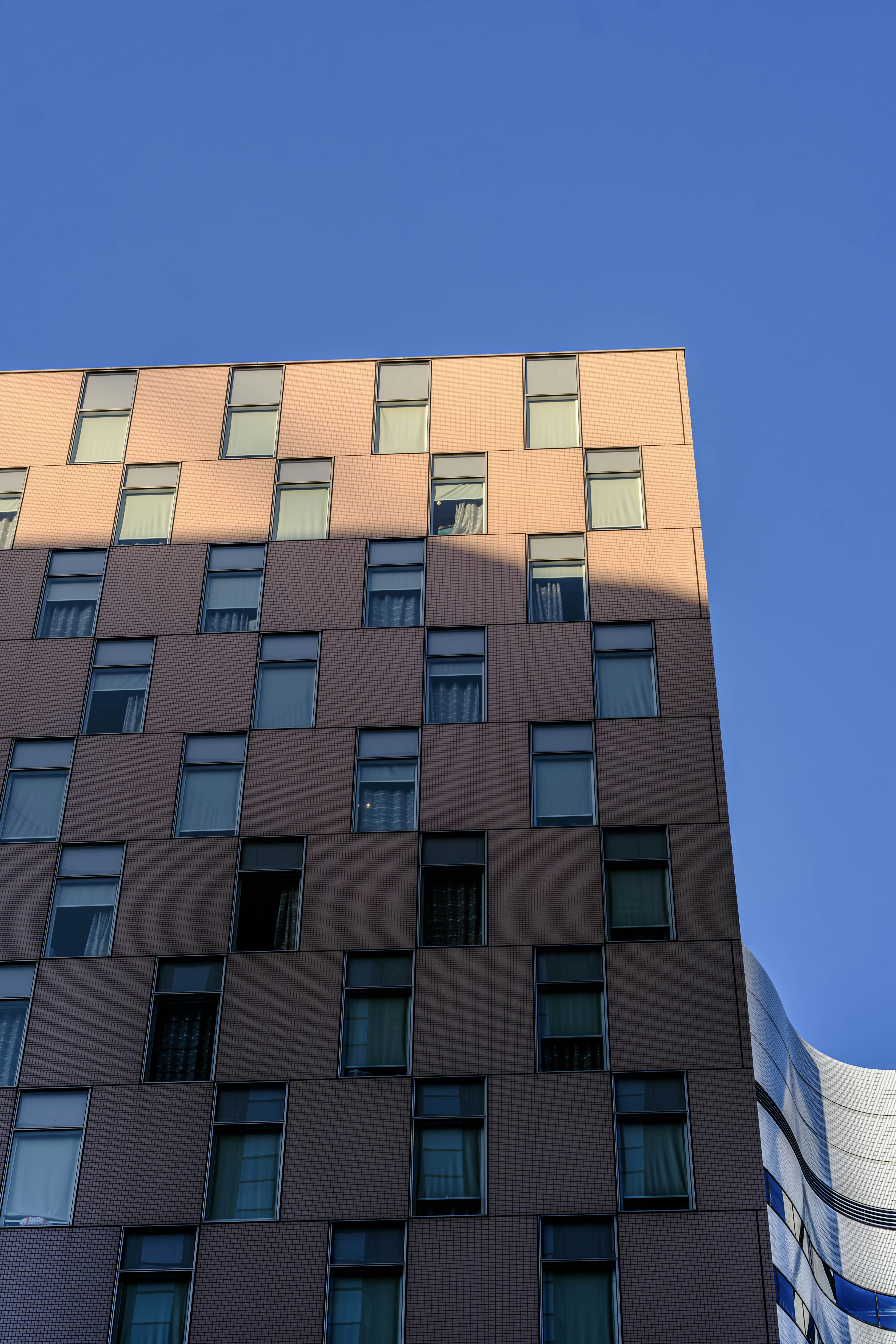 Modern building facade with many windows against blue sky