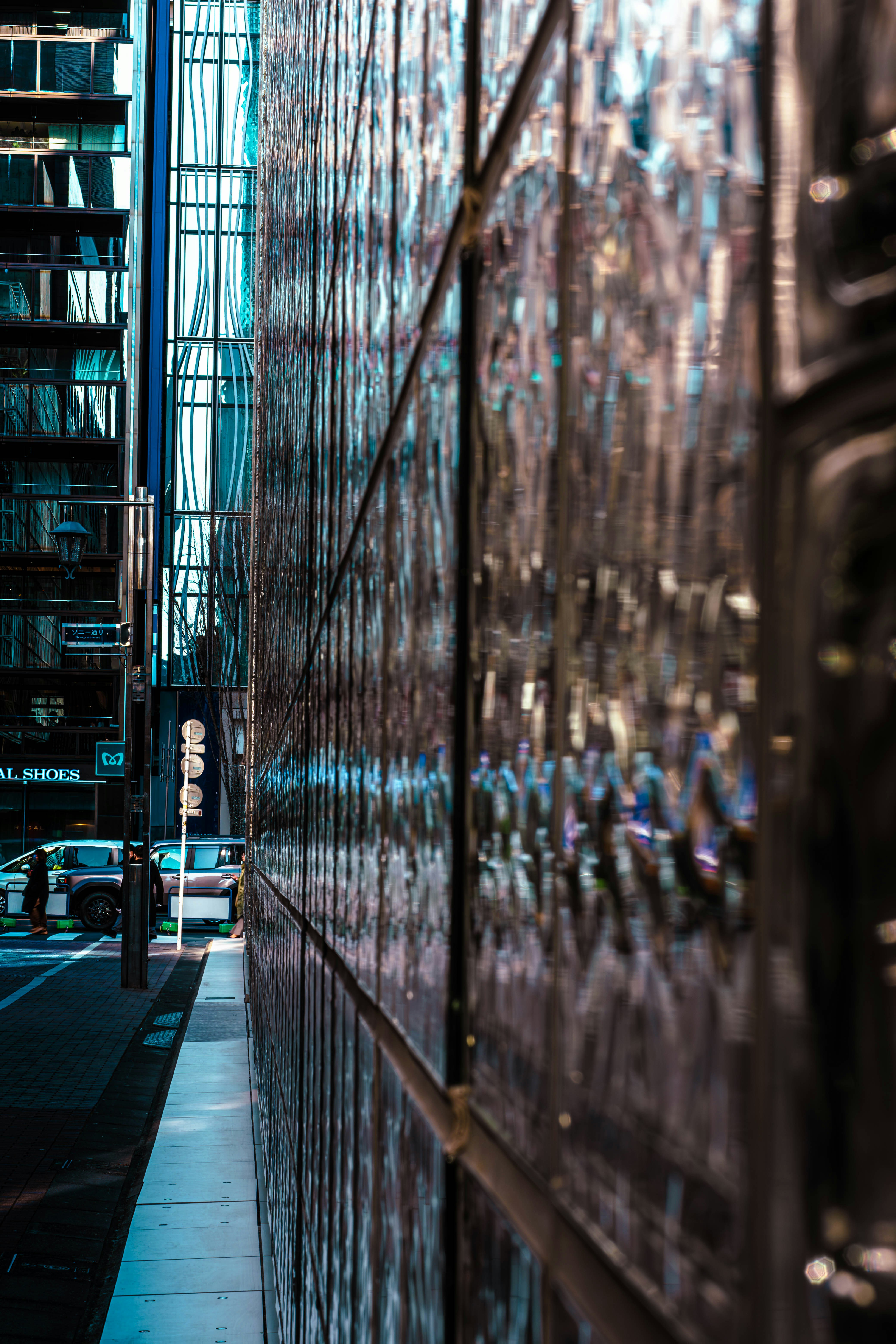 Modern glass building facade reflecting city street