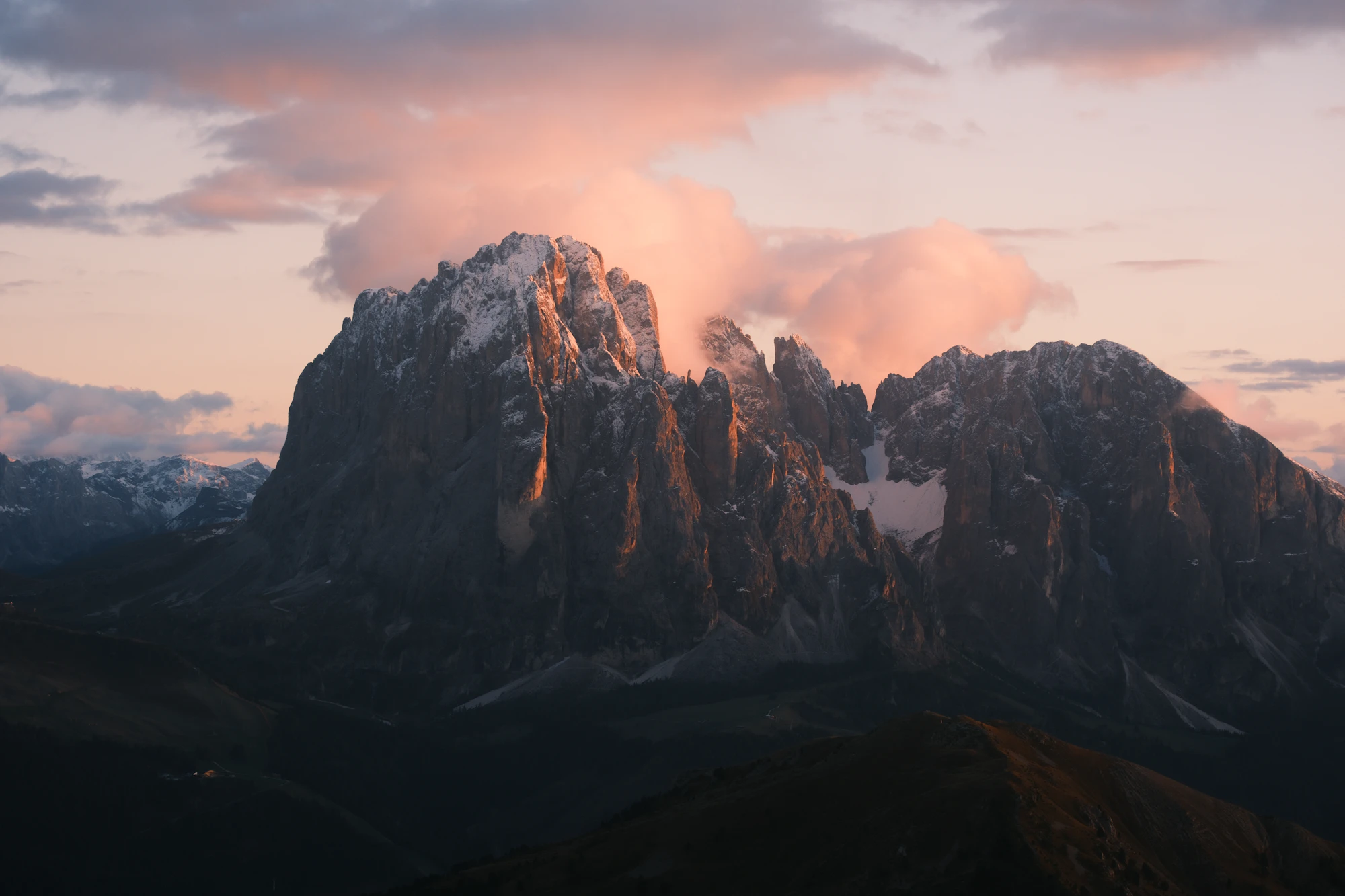 Snow capped mountains bathed in soft sunset light