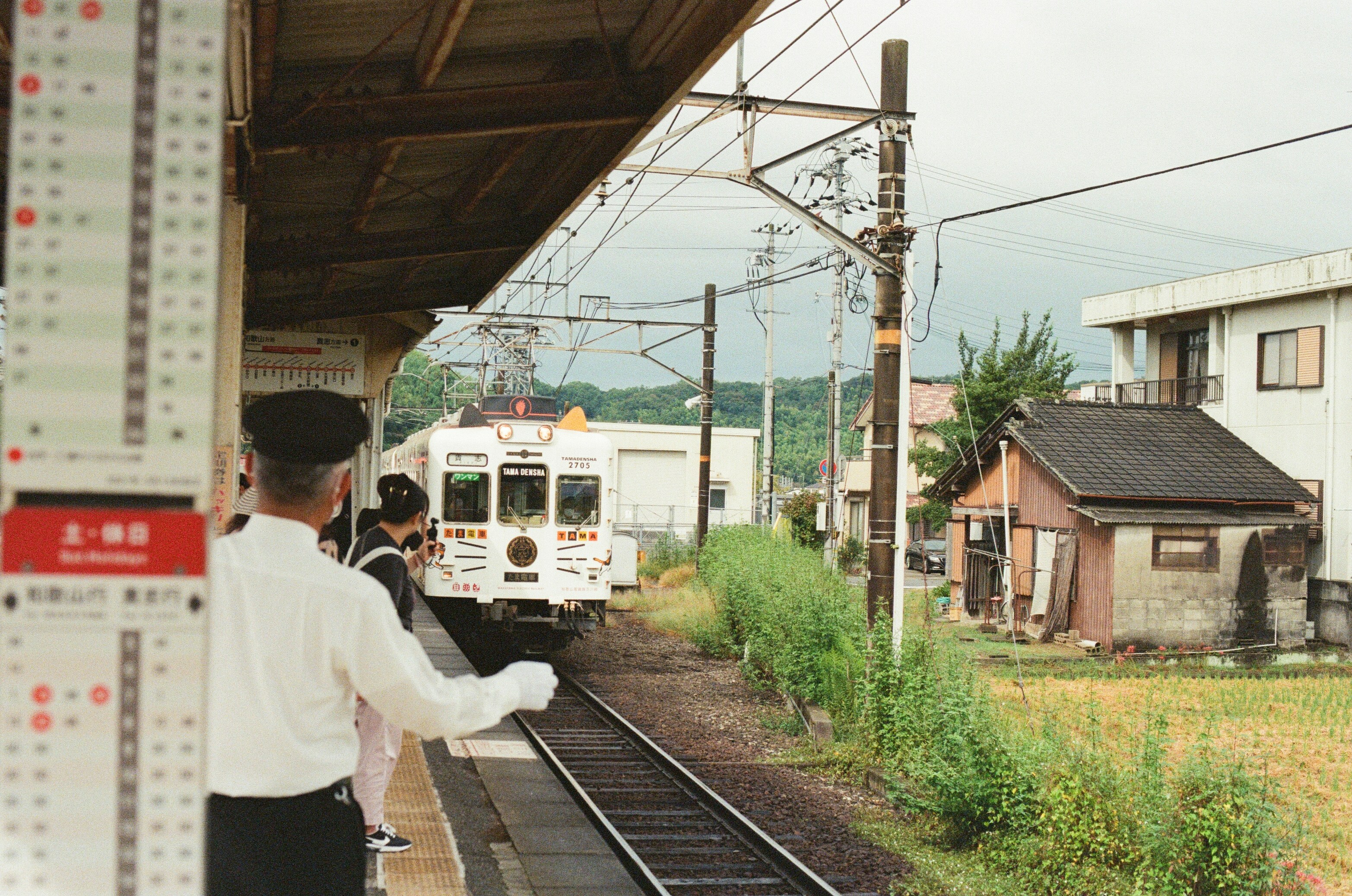 Train arriving at a rural station with conductor
