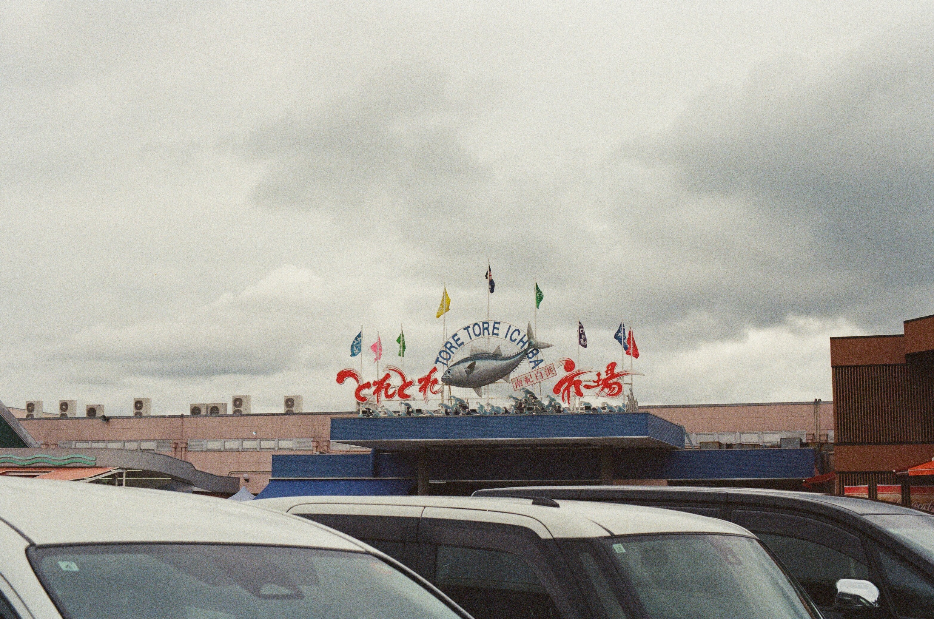 Building with shark sign and flags under cloudy sky