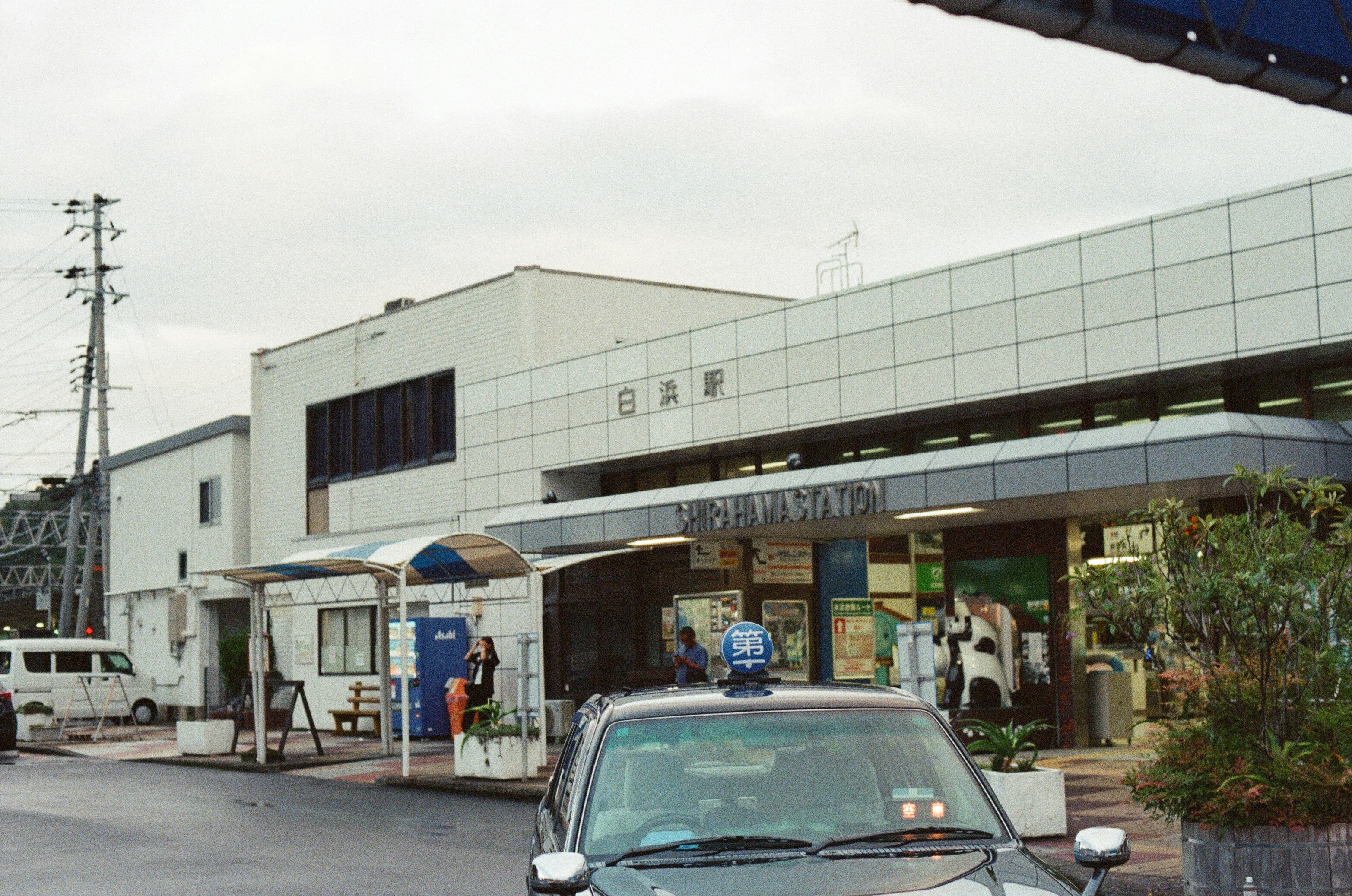 A japanese train station entrance with a taxi
