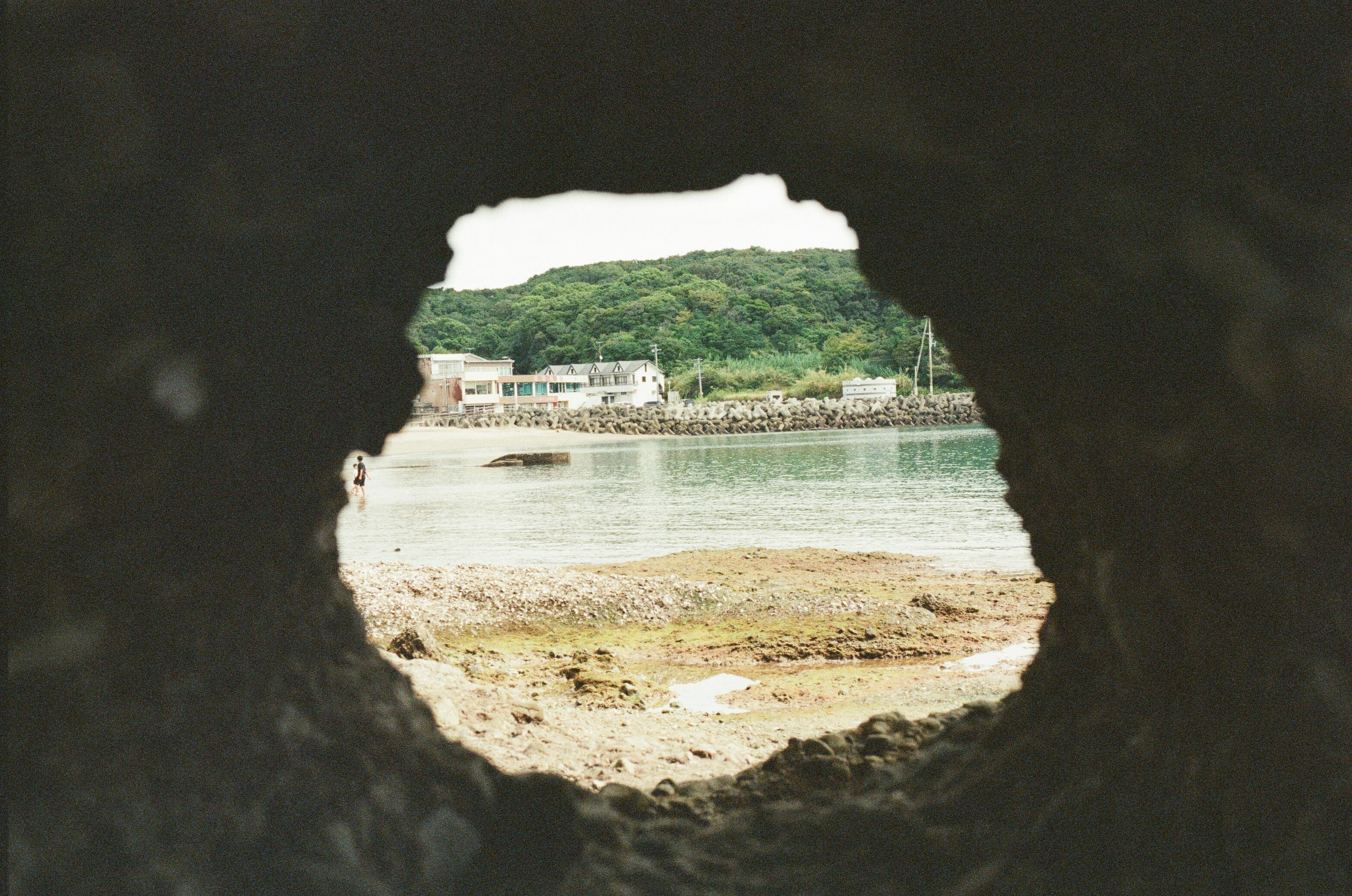 View of a coastal town through a rock opening