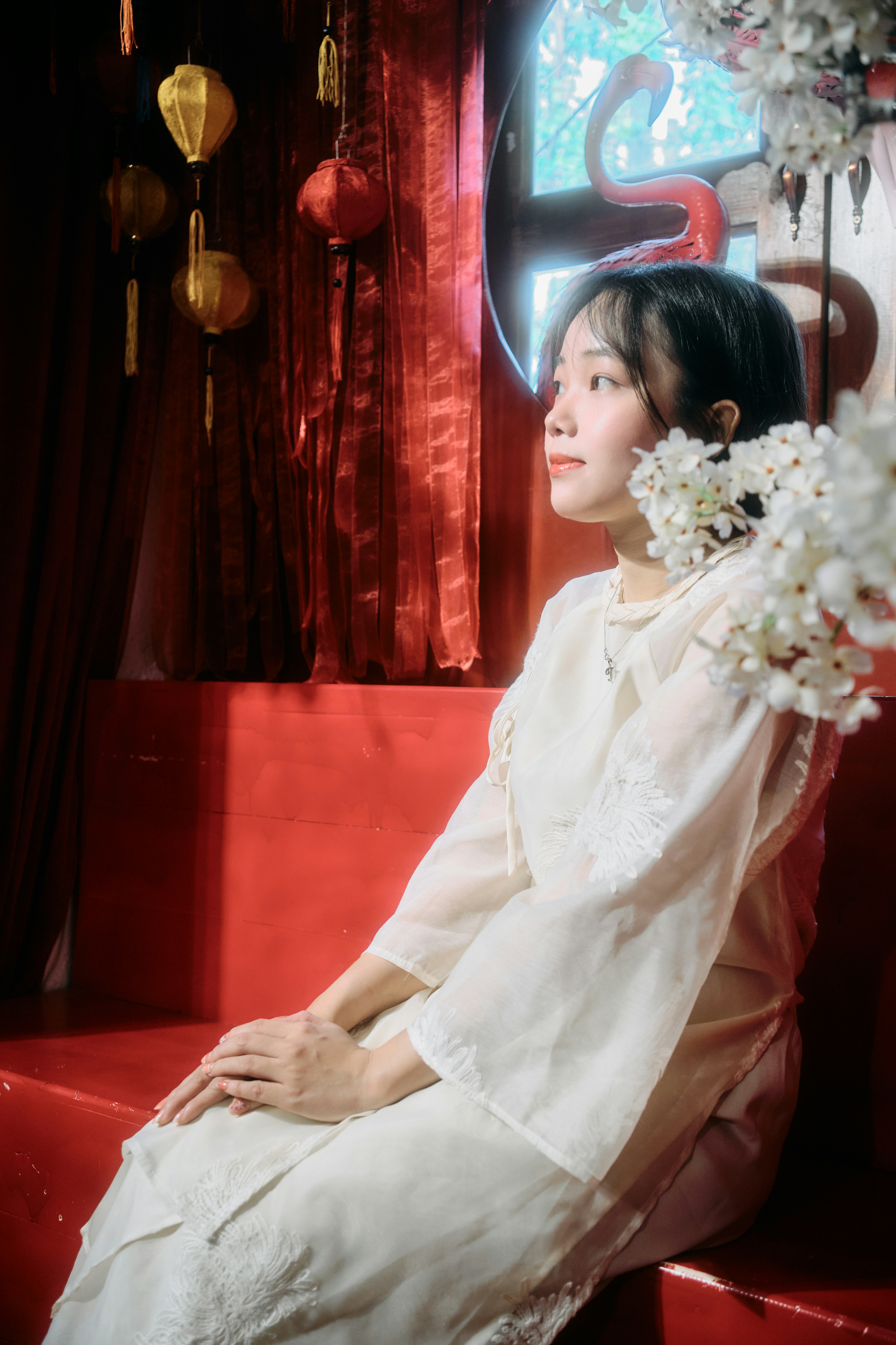 Young woman in white dress with red background