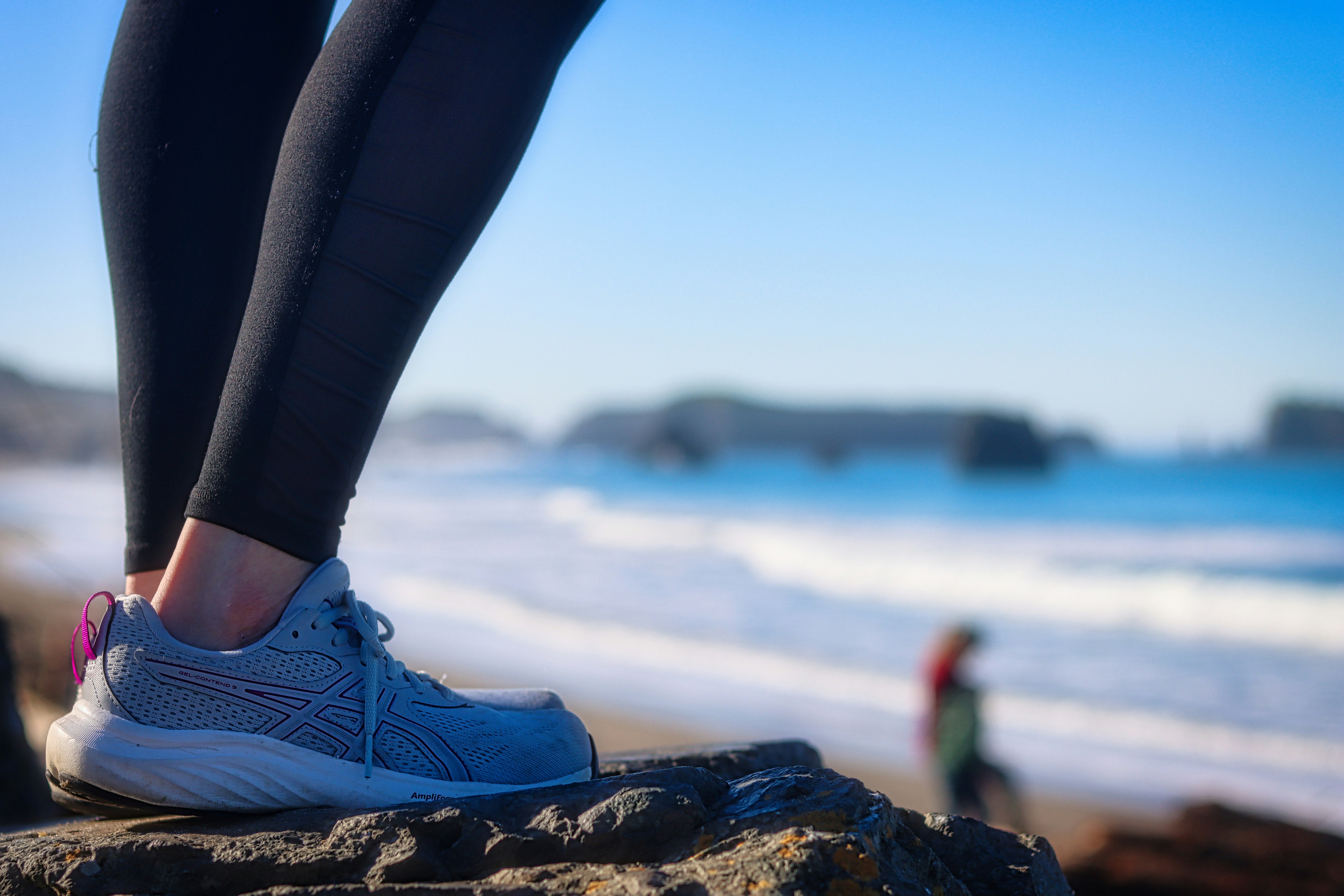 Person standing on rocks by the ocean