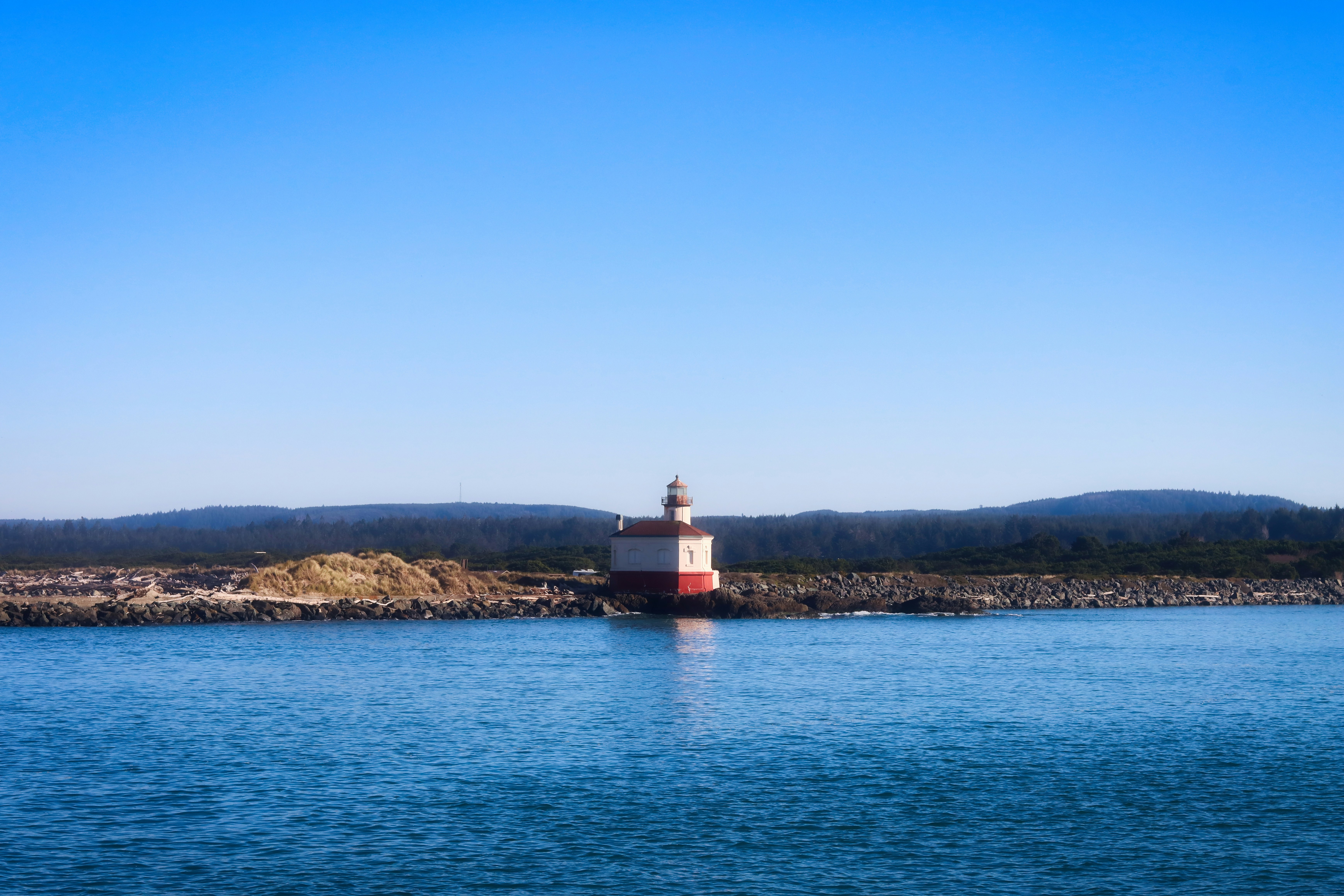 Lighthouse on a rocky shore with blue sky
