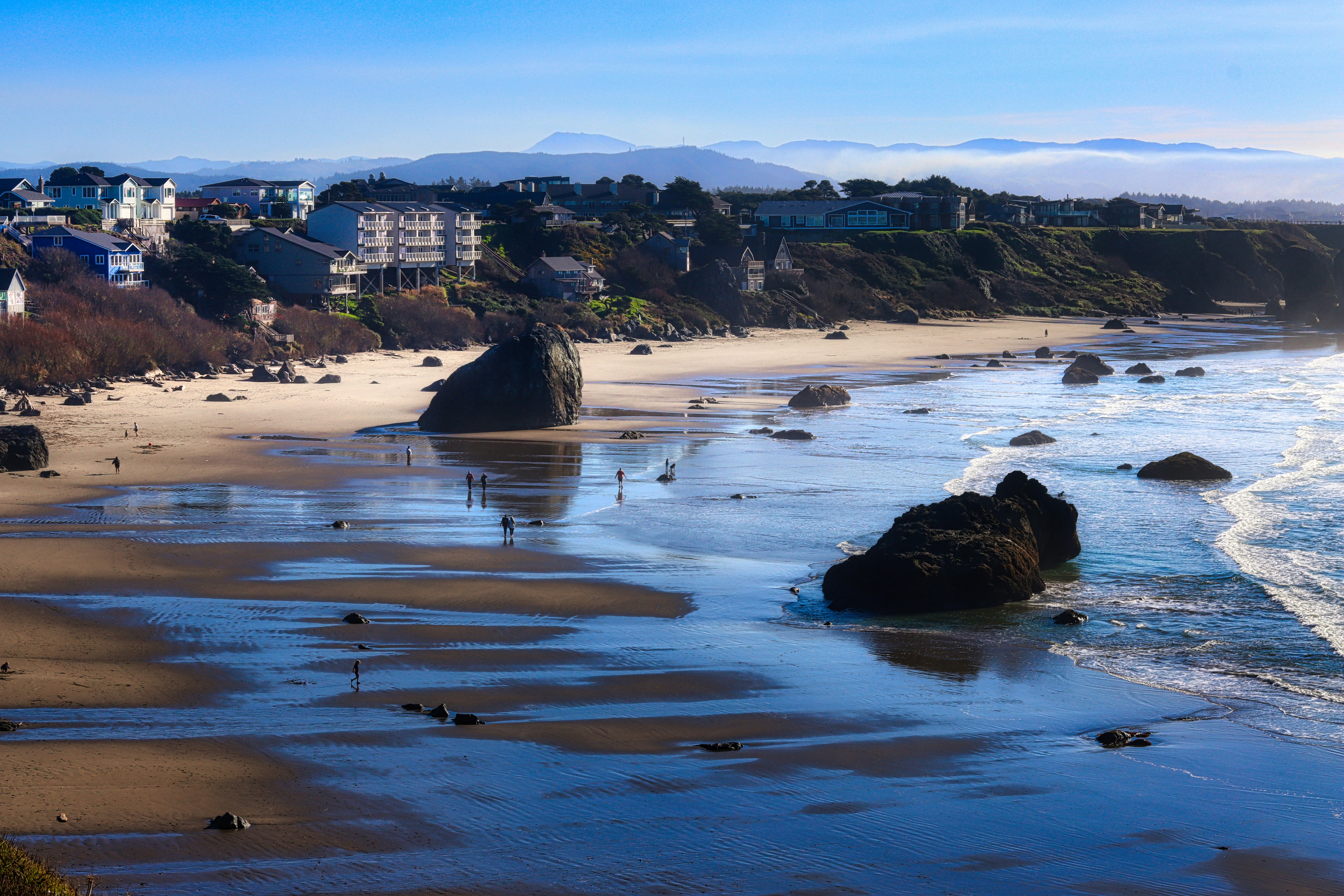Coastal town on a sunny day with rocky beach.