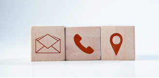 Wooden blocks with contact icons: envelope, phone, location.