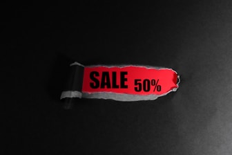 Red tag with "sale 50%" text on black background