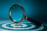 Magnifying glass over a target with bullseye
