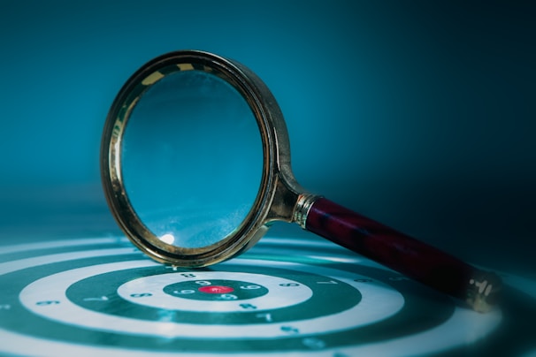 Magnifying glass over a target with bullseye.