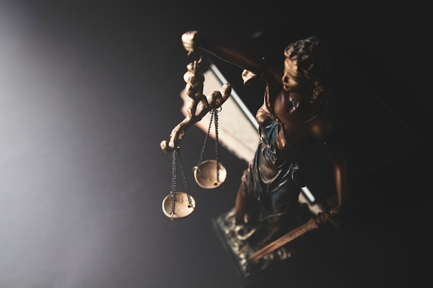Statue of justice with scales on dark background